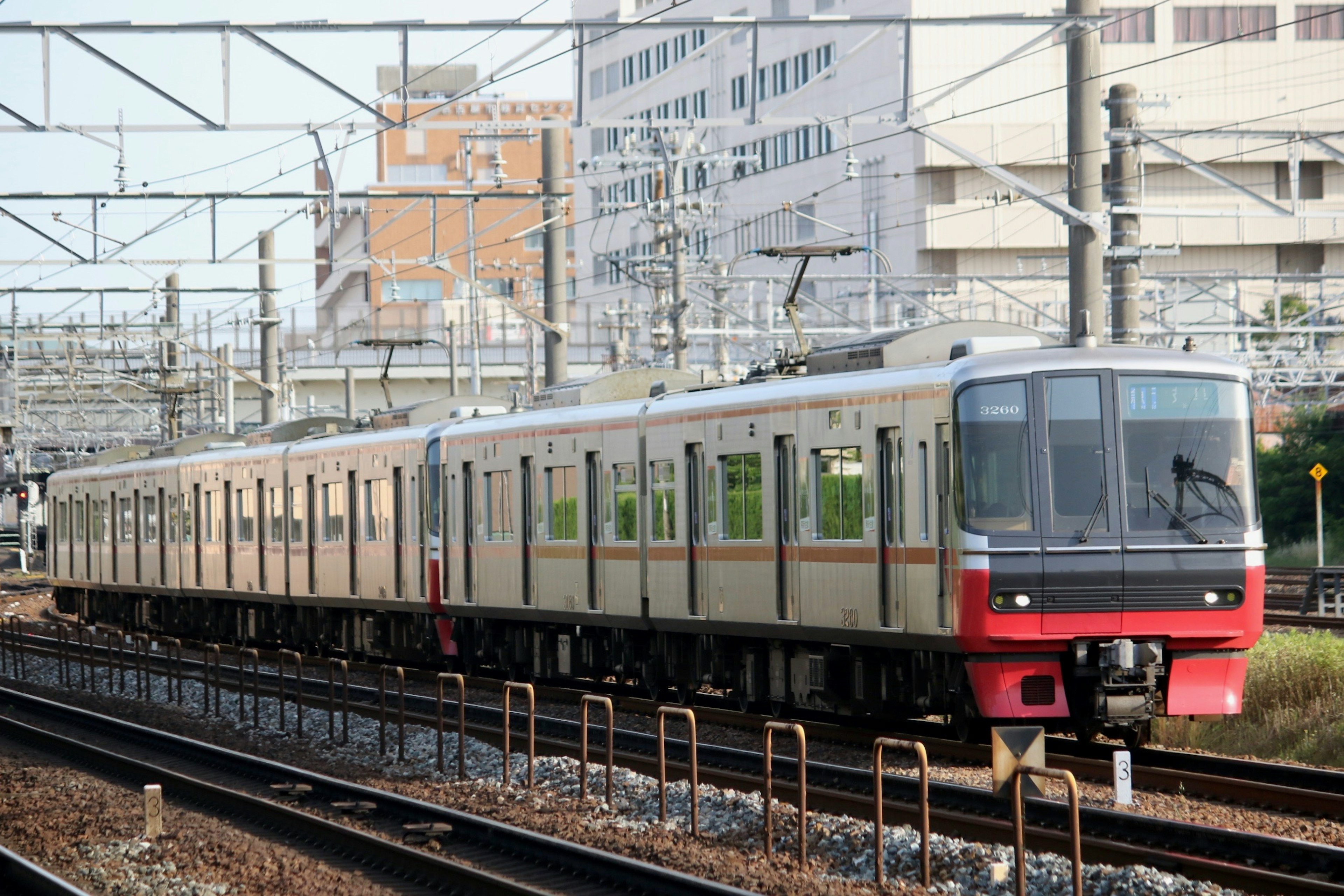 รถไฟสีเงินและสีแดงที่วิ่งอยู่บนราง