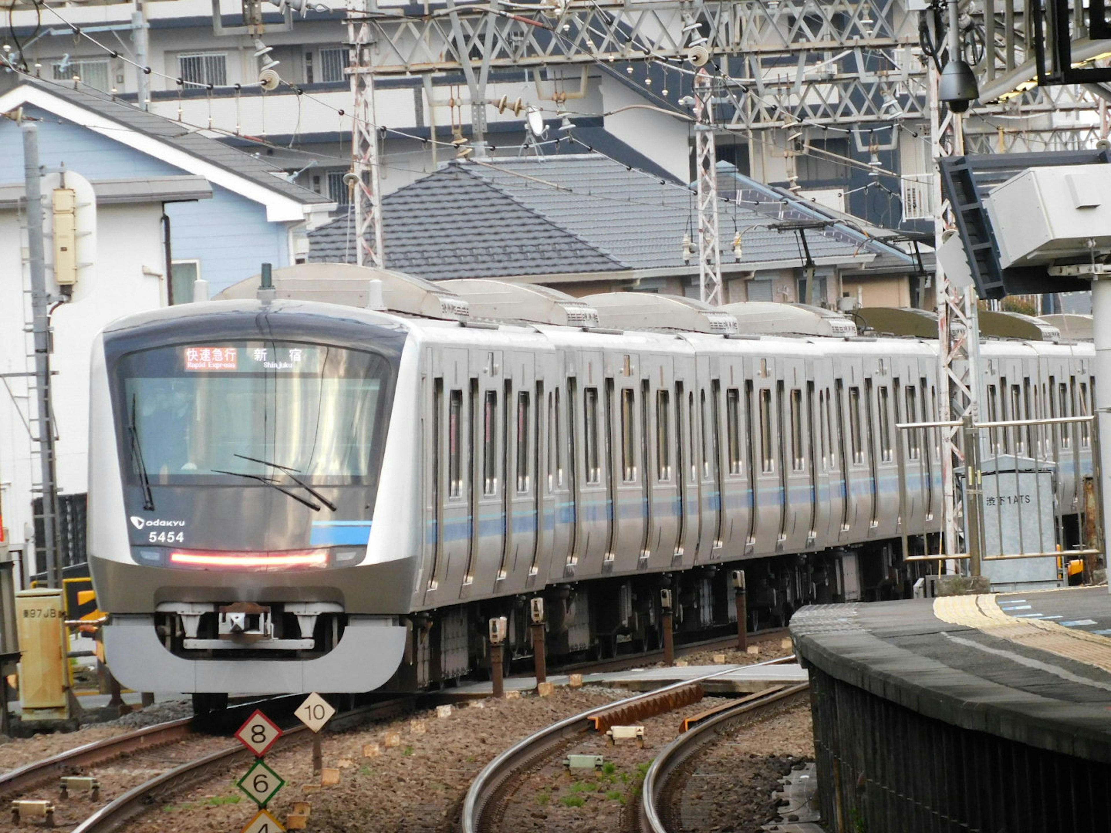 Tren moderno en las vías con casas circundantes