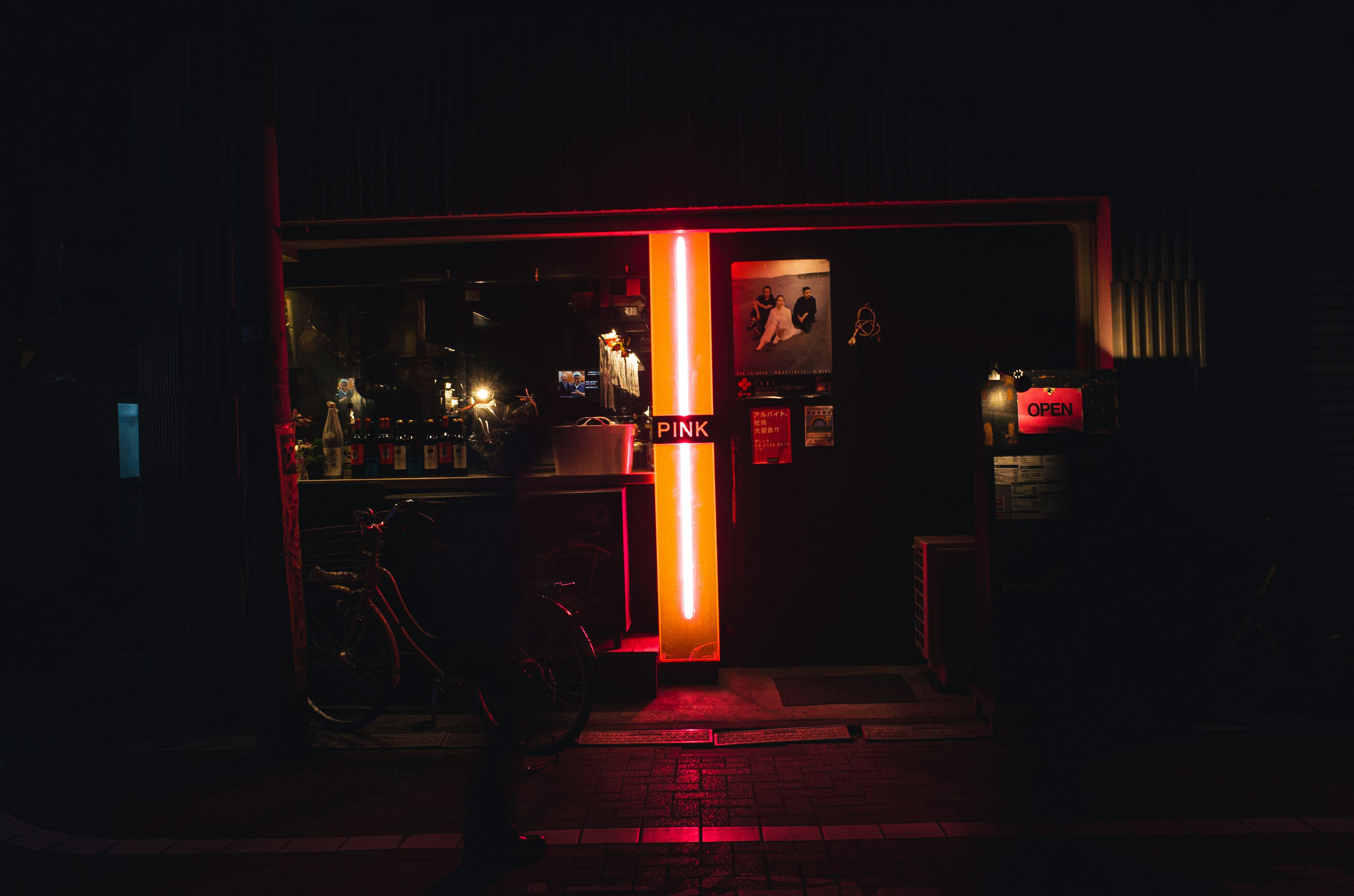 Esterno di un bar di notte Luci al neon rosse brillanti attirano l'attenzione Una bicicletta è parcheggiata