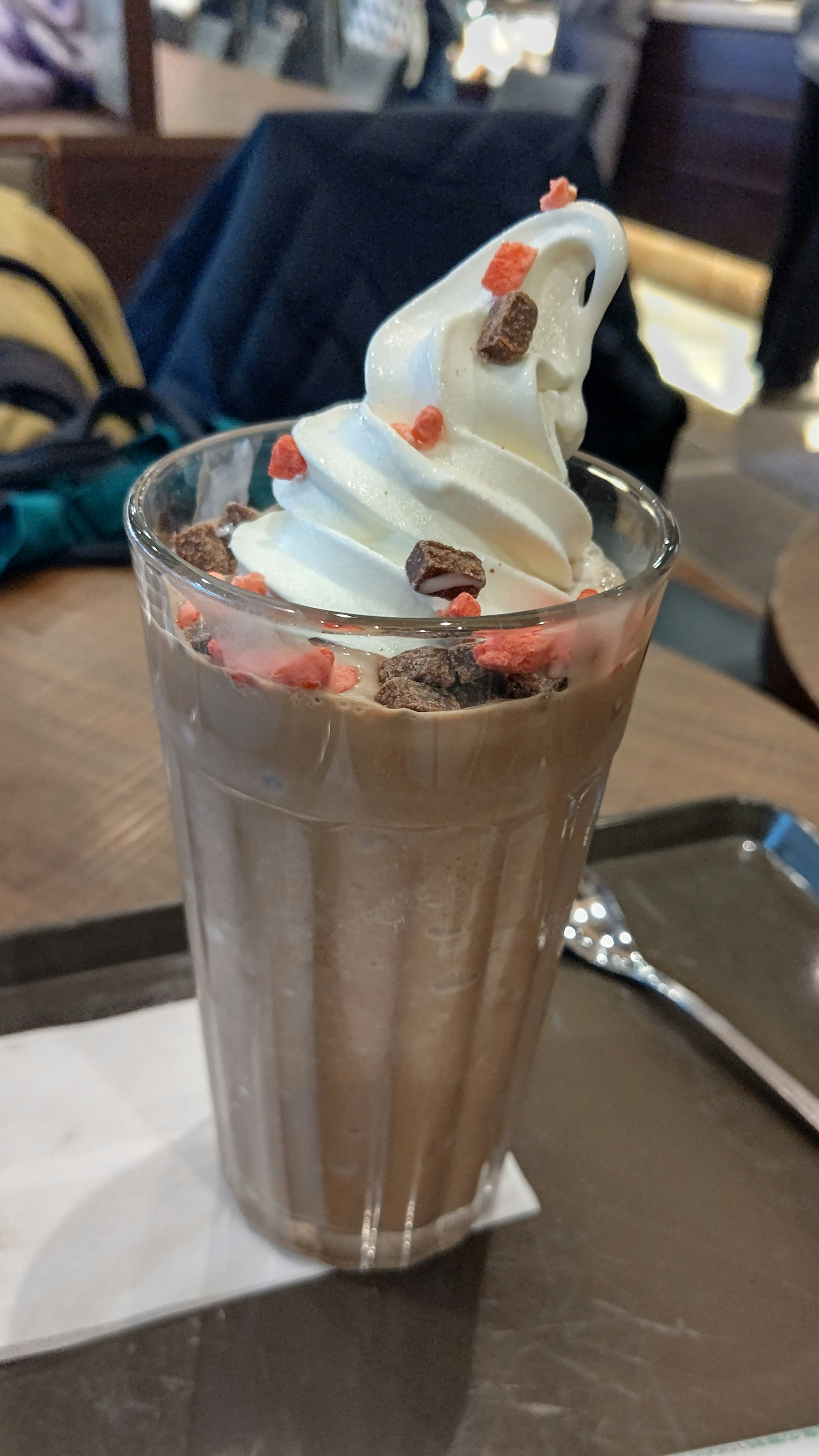 Chocolate shake topped with whipped cream and colorful sprinkles