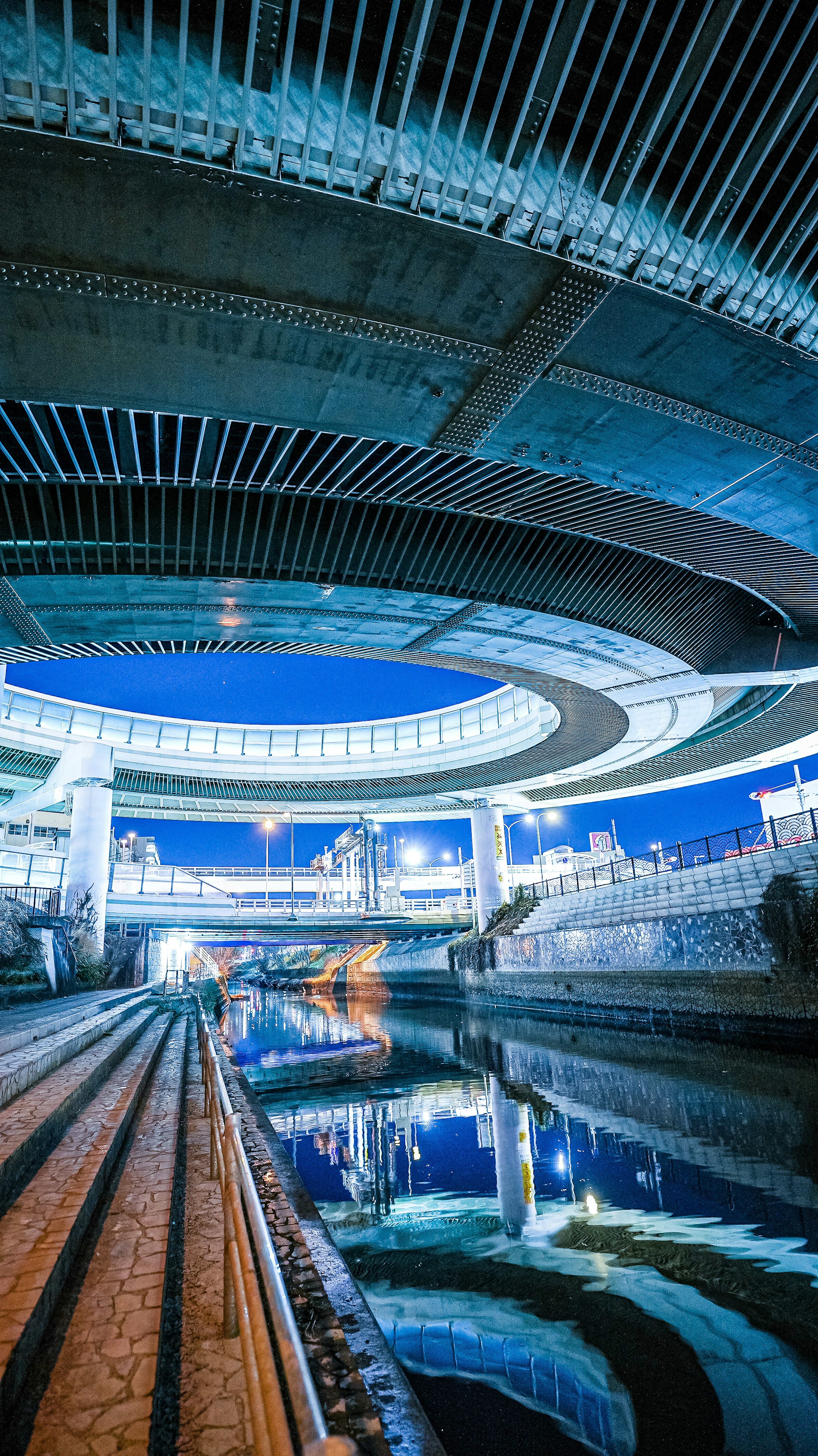 Moderne architektonische Struktur über einem Fluss, der den blauen Himmel und das Wasser reflektiert