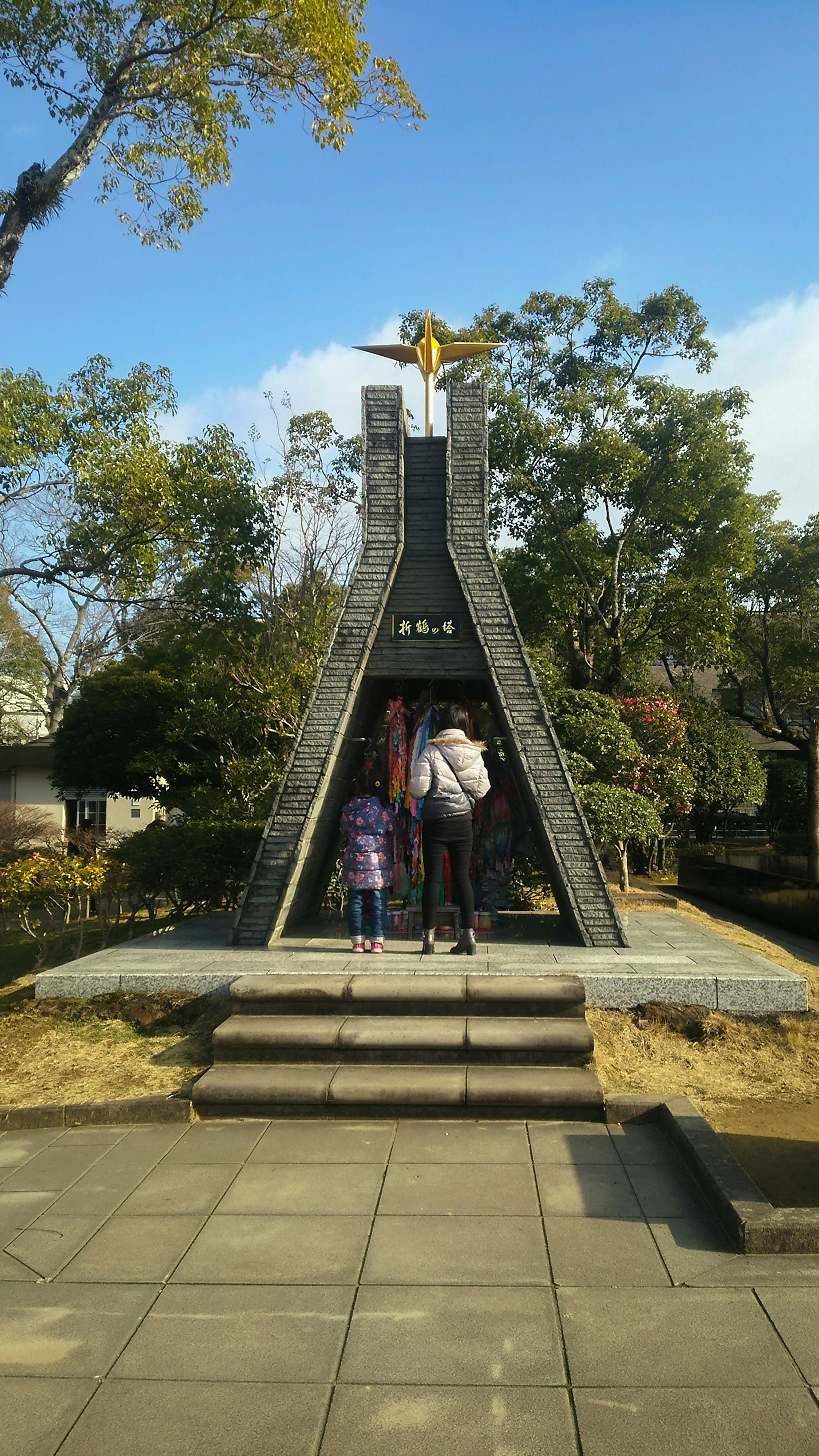 公園の中にある現代的なモニュメントを訪れる家族