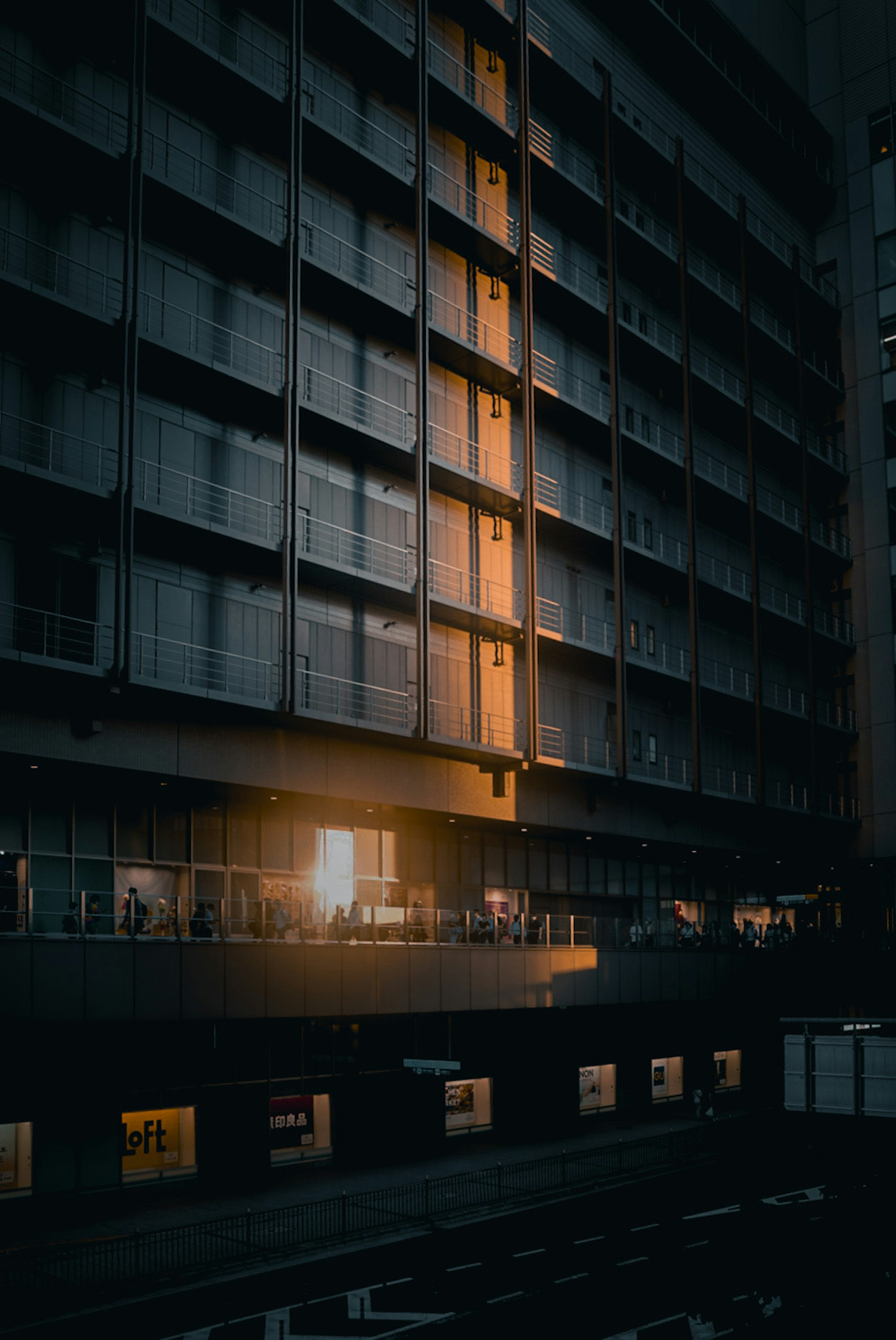 Fachada de edificio urbano oscuro con ventanas iluminadas