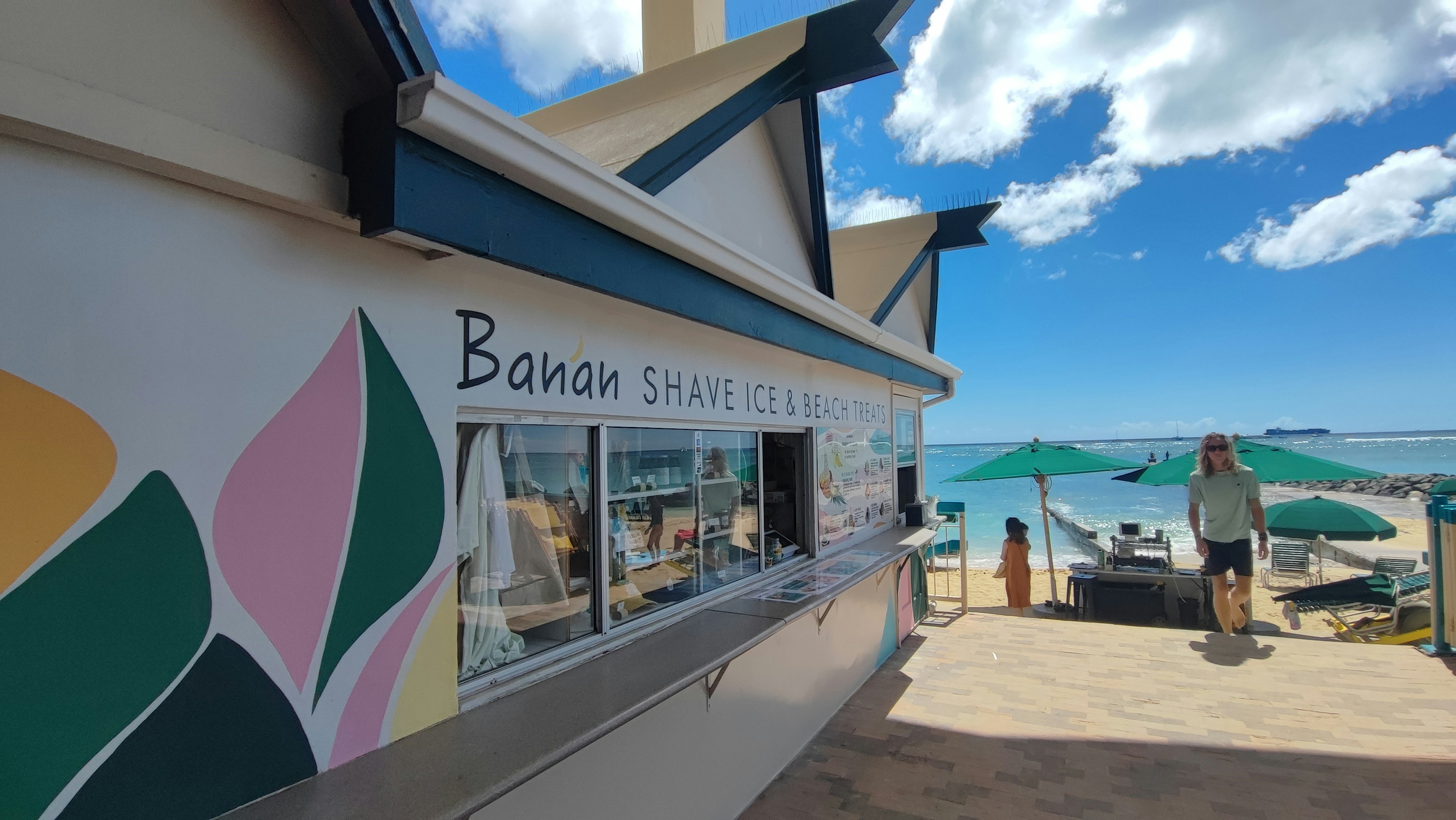 Außenansicht eines Bananensnackstands am Strand mit blauem Himmel und Ozean im Hintergrund