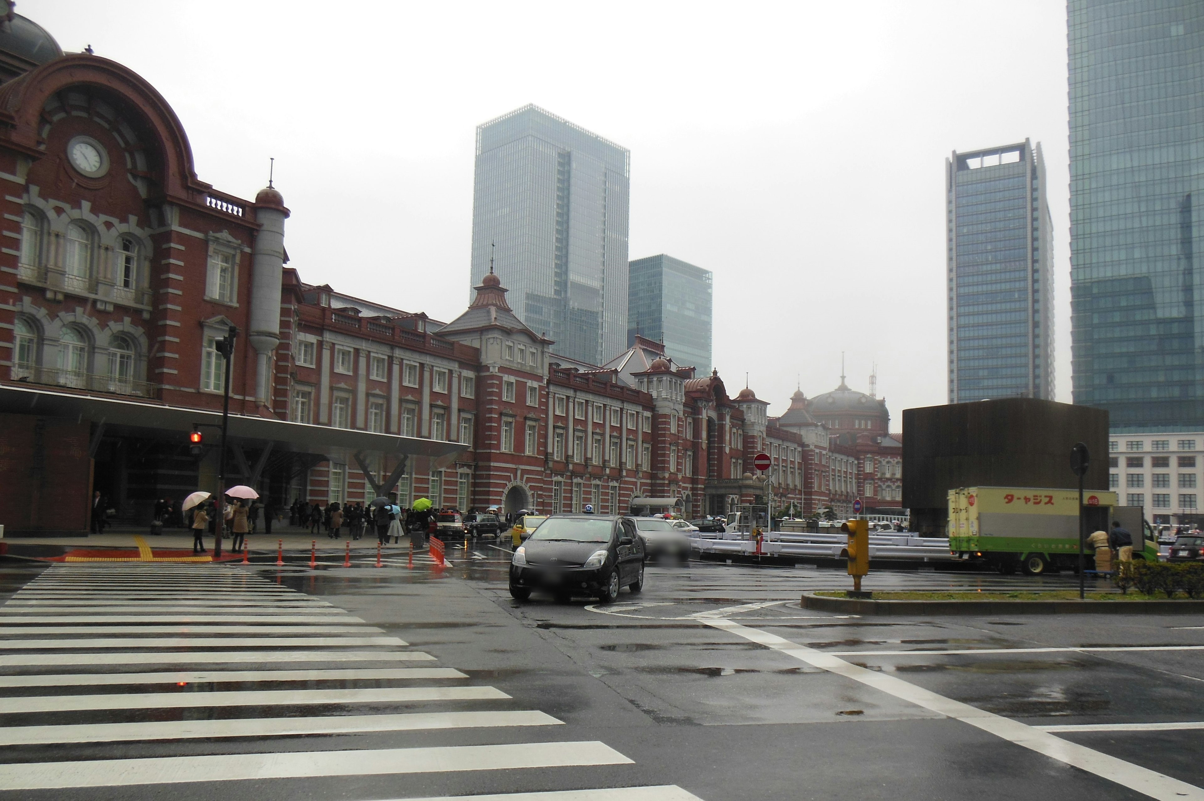 Vue pluvieuse de la gare de Tokyo avec une architecture historique et des gratte-ciels modernes