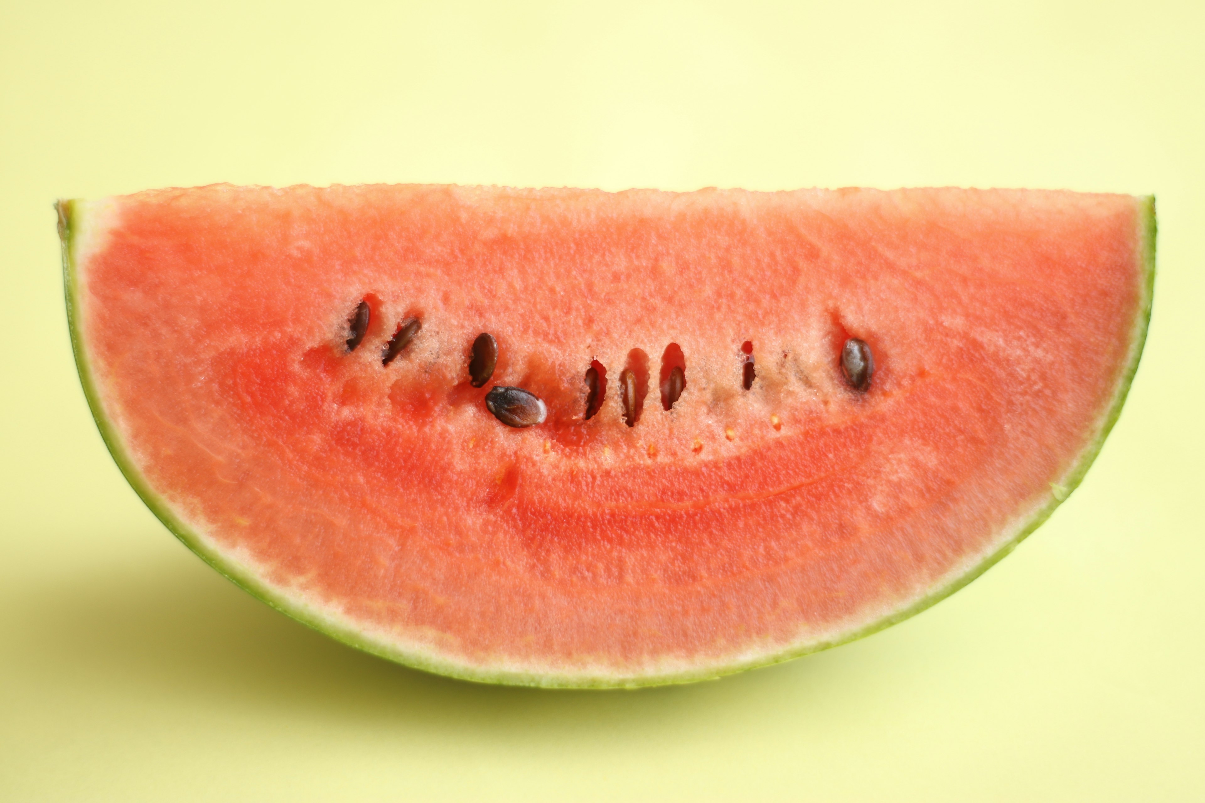 Eine halbe Wassermelone auf einem gelben Hintergrund