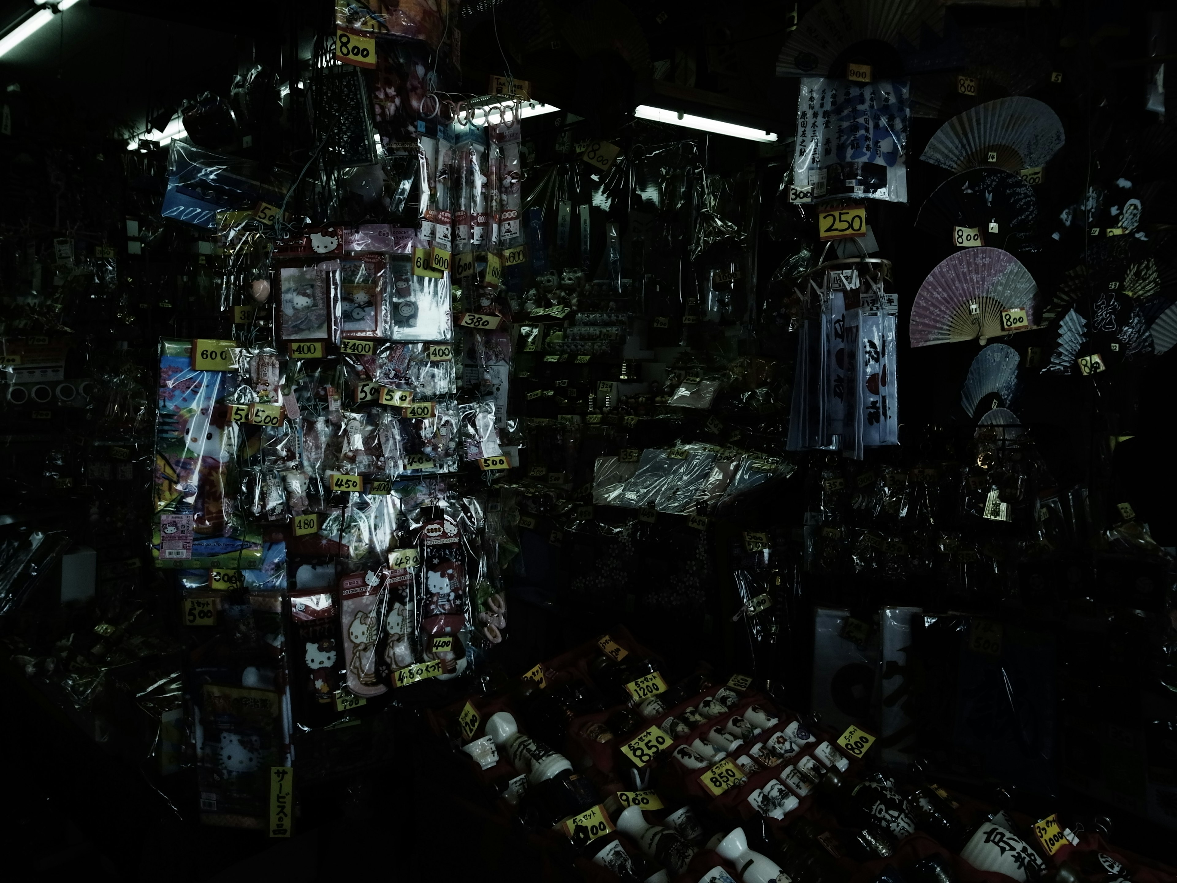 Dark marketplace display filled with various items and toys