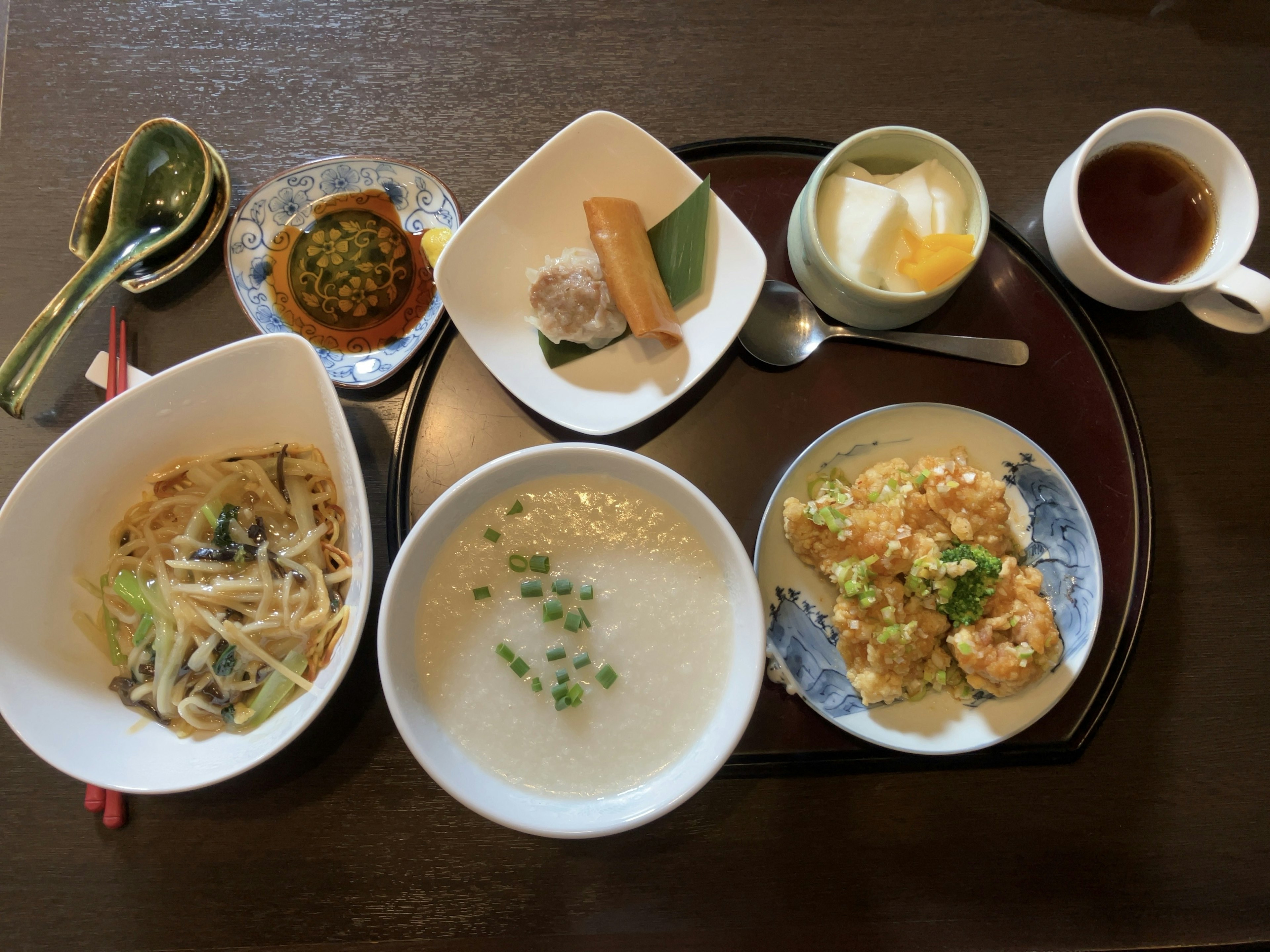 Un delicioso conjunto de comida japonesa con plato de fideos, porridge de arroz, tempura de camarones y postre