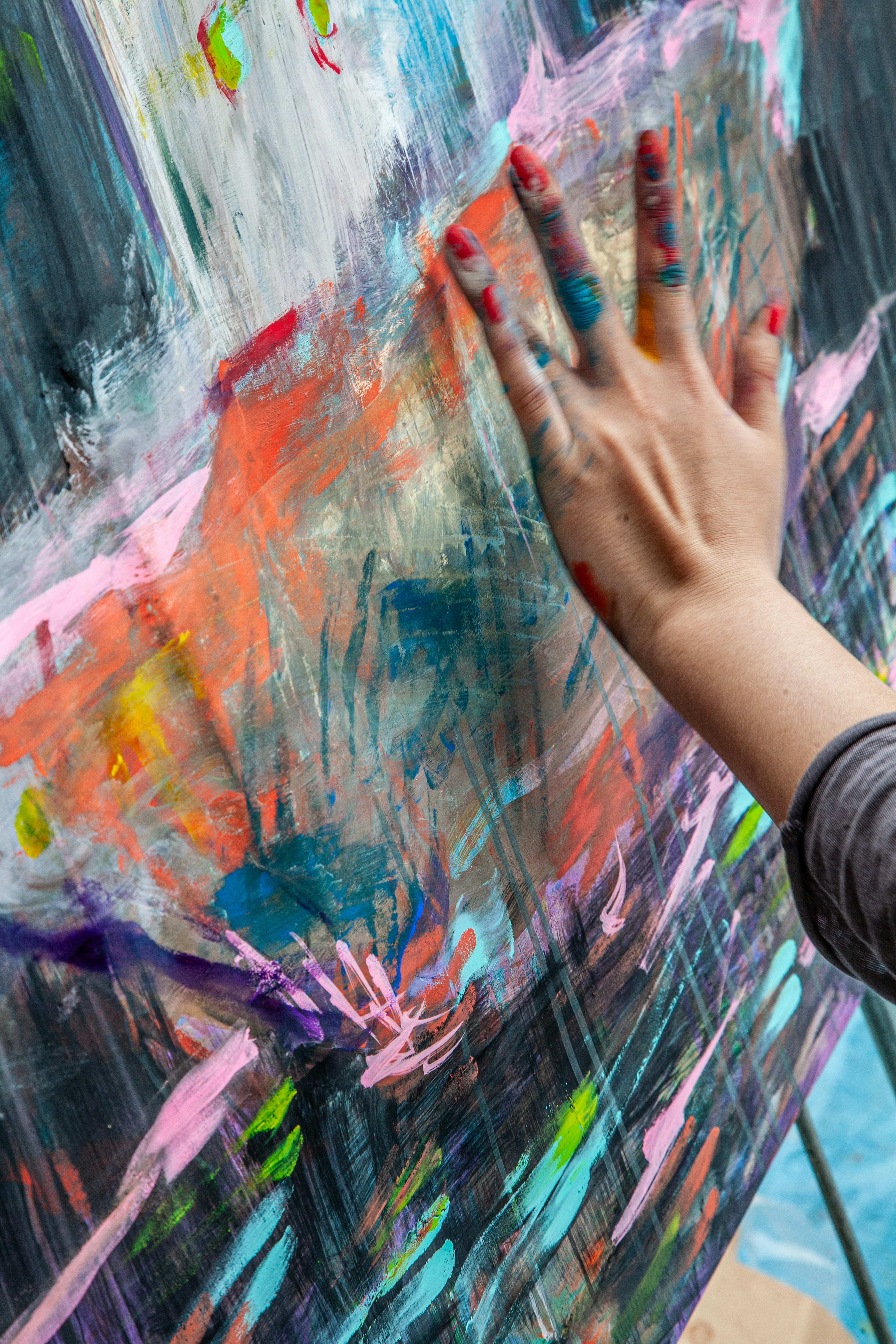 Hand touching a colorful painted canvas