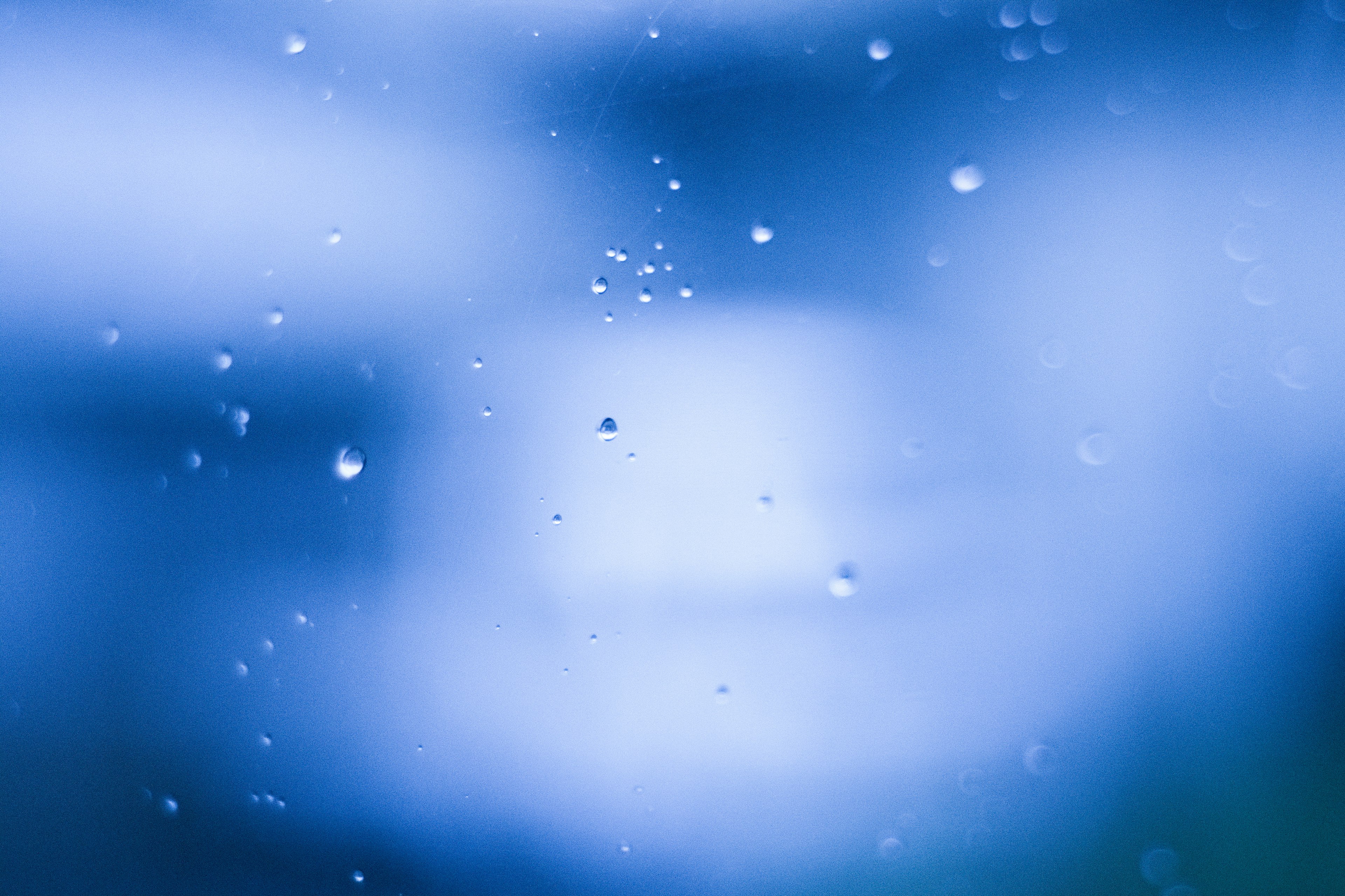 Blurred image with water droplets against a blue background