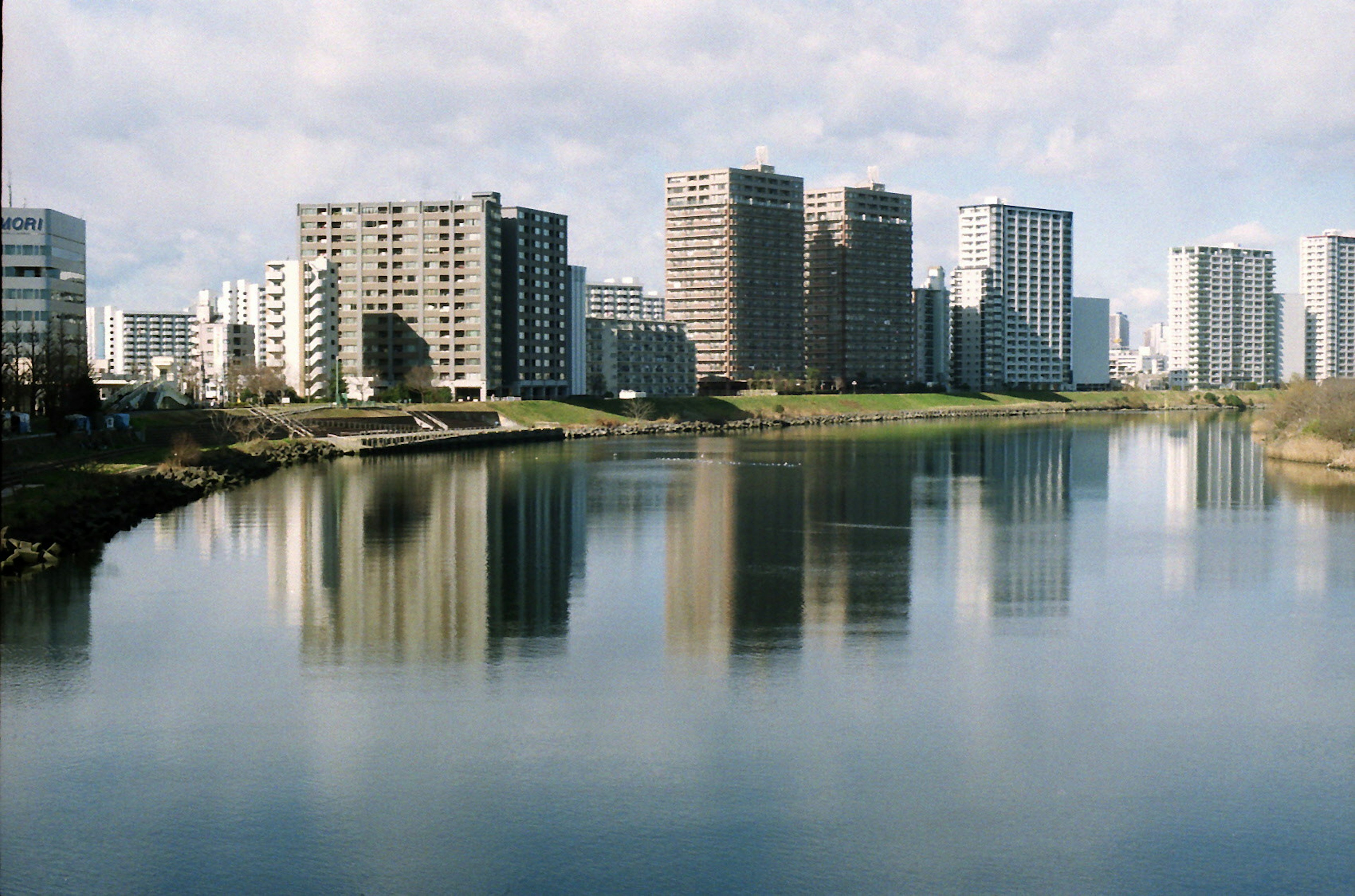 Paesaggio urbano con un fiume tranquillo e riflessi di alti edifici