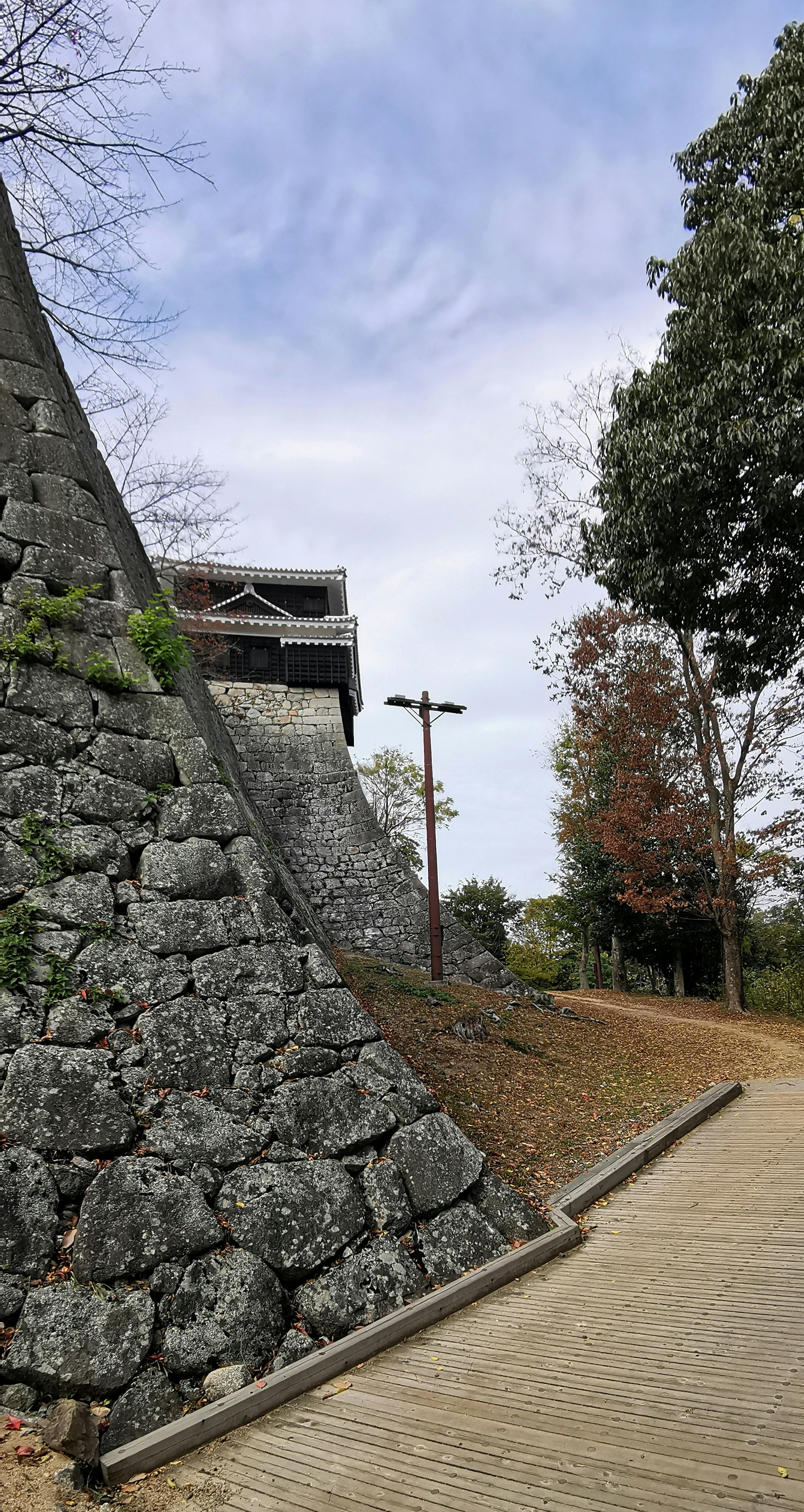 Eine Parkszene mit einer Steinmauer und einem Holzweg