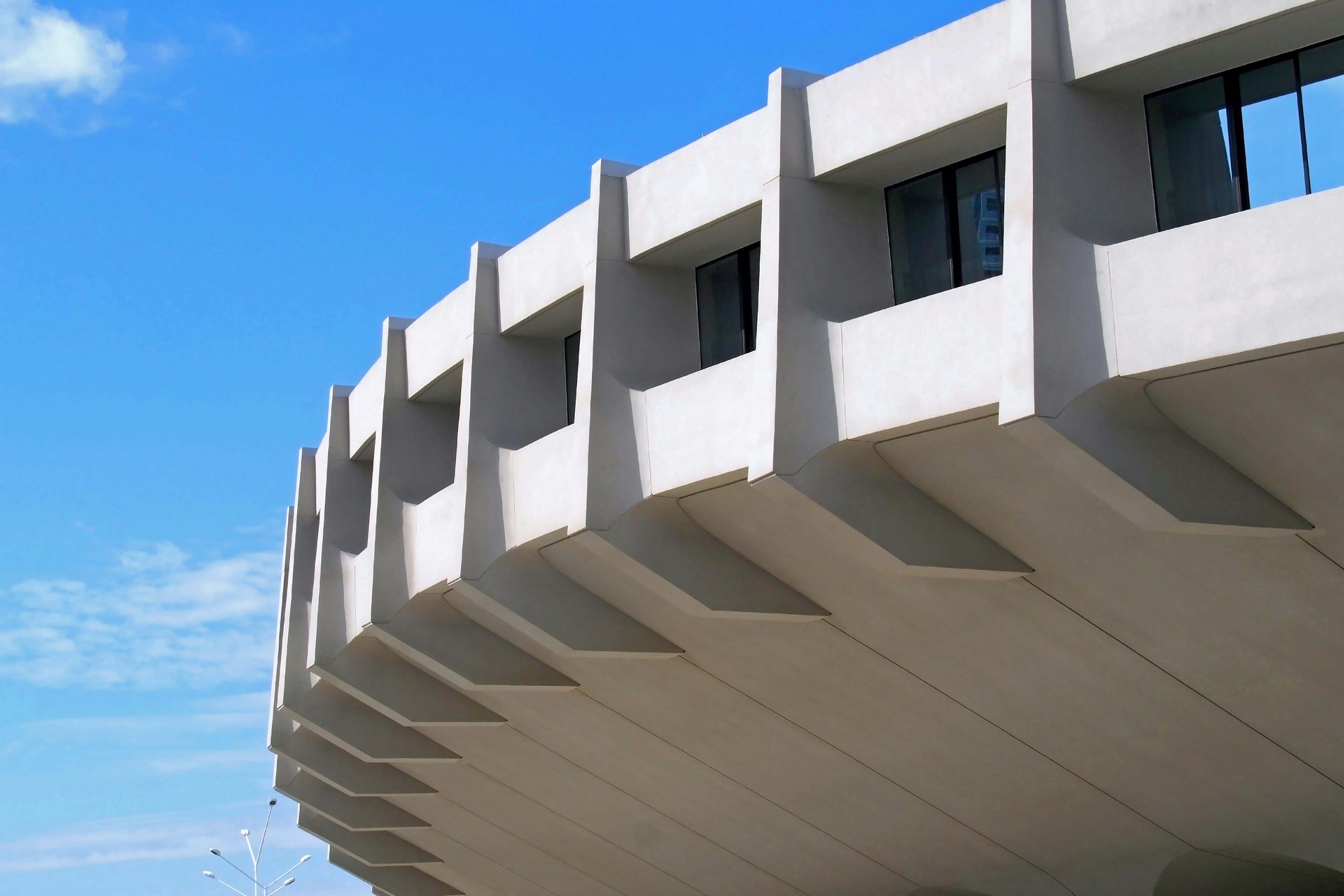 Einzigartiges Design eines Betonteils mit Fenstern und blauem Himmel