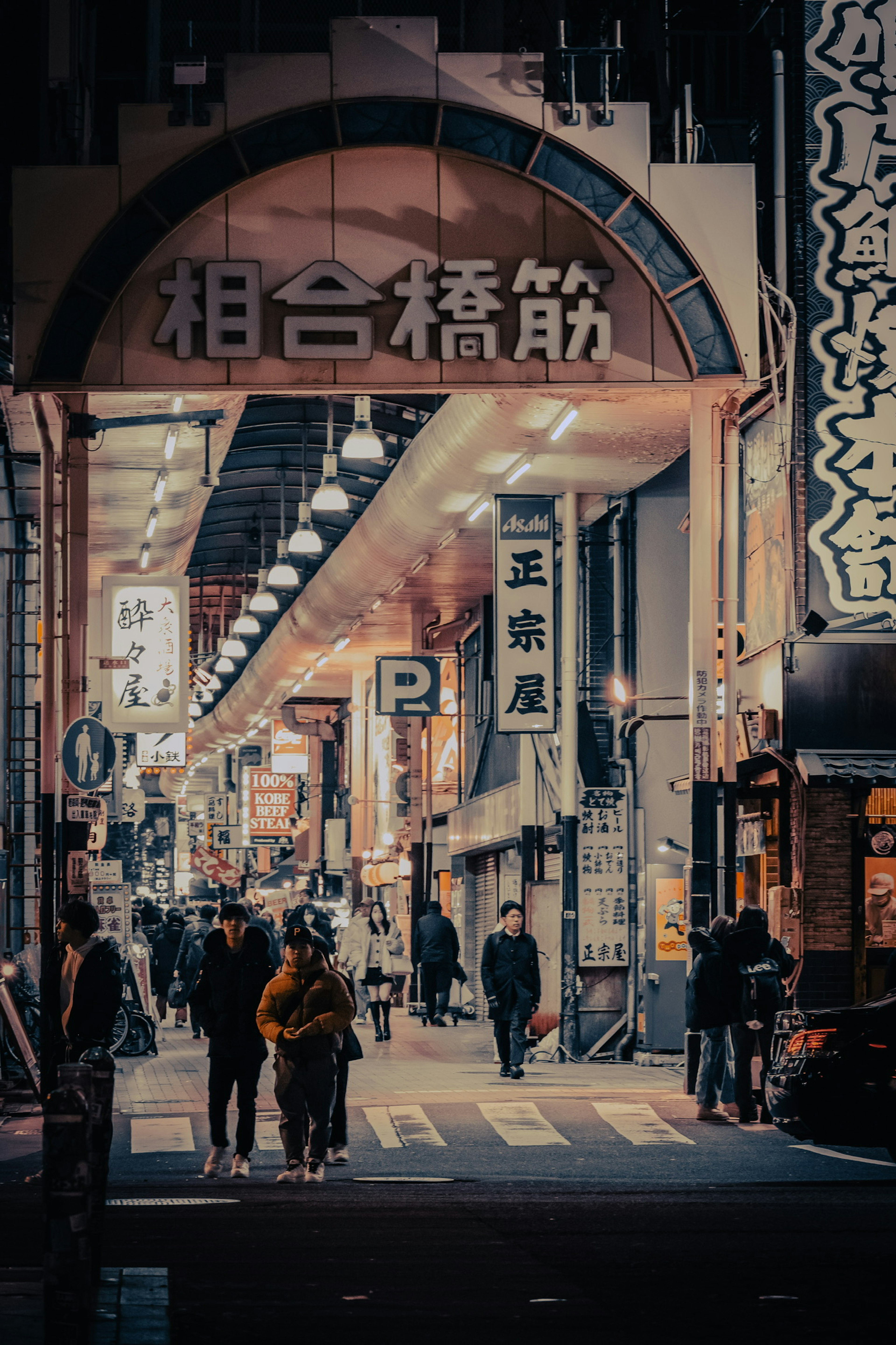 Night street scene with arcade and pedestrians