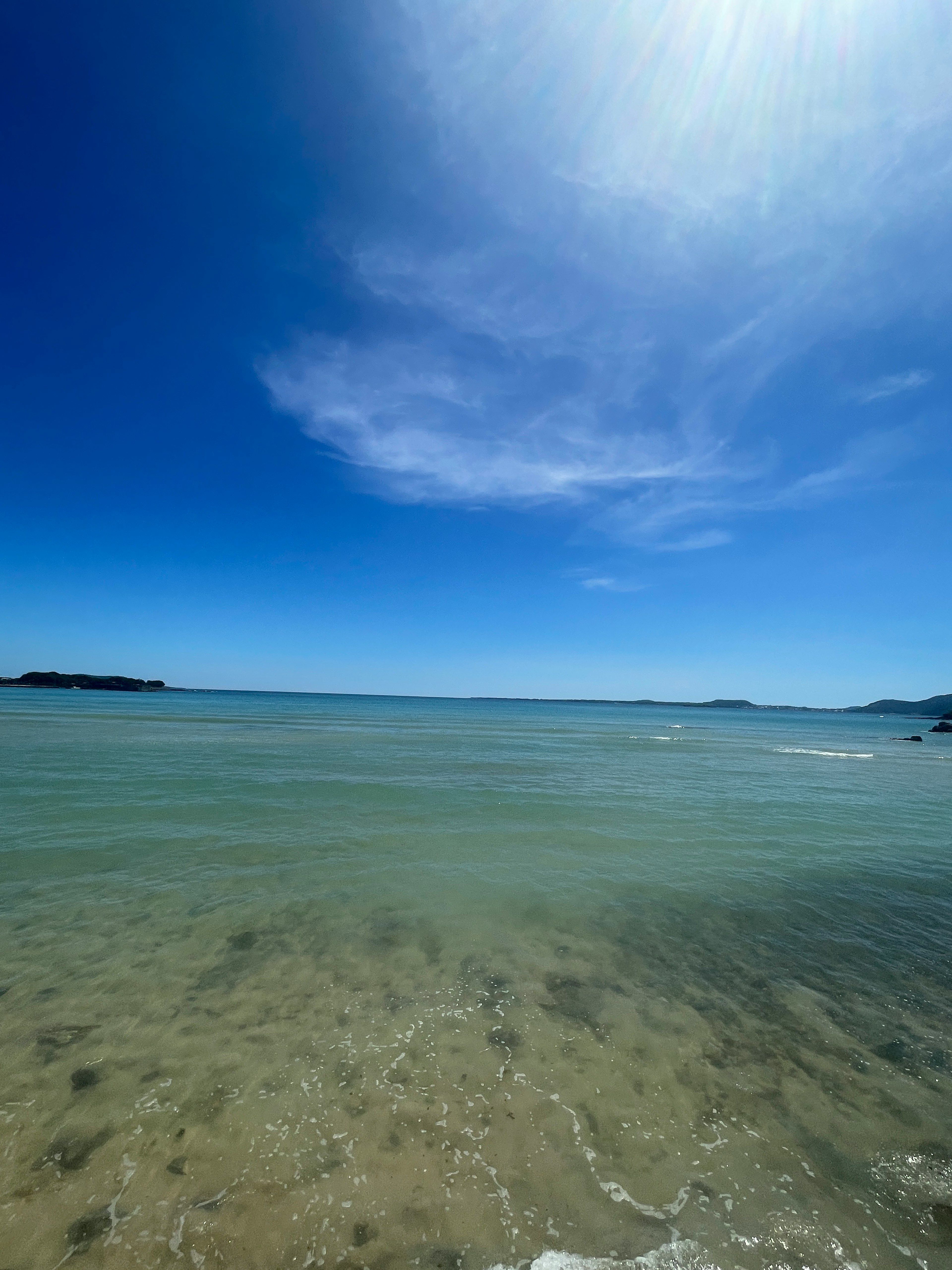 Scenic view of clear water and blue sky with visible seabed