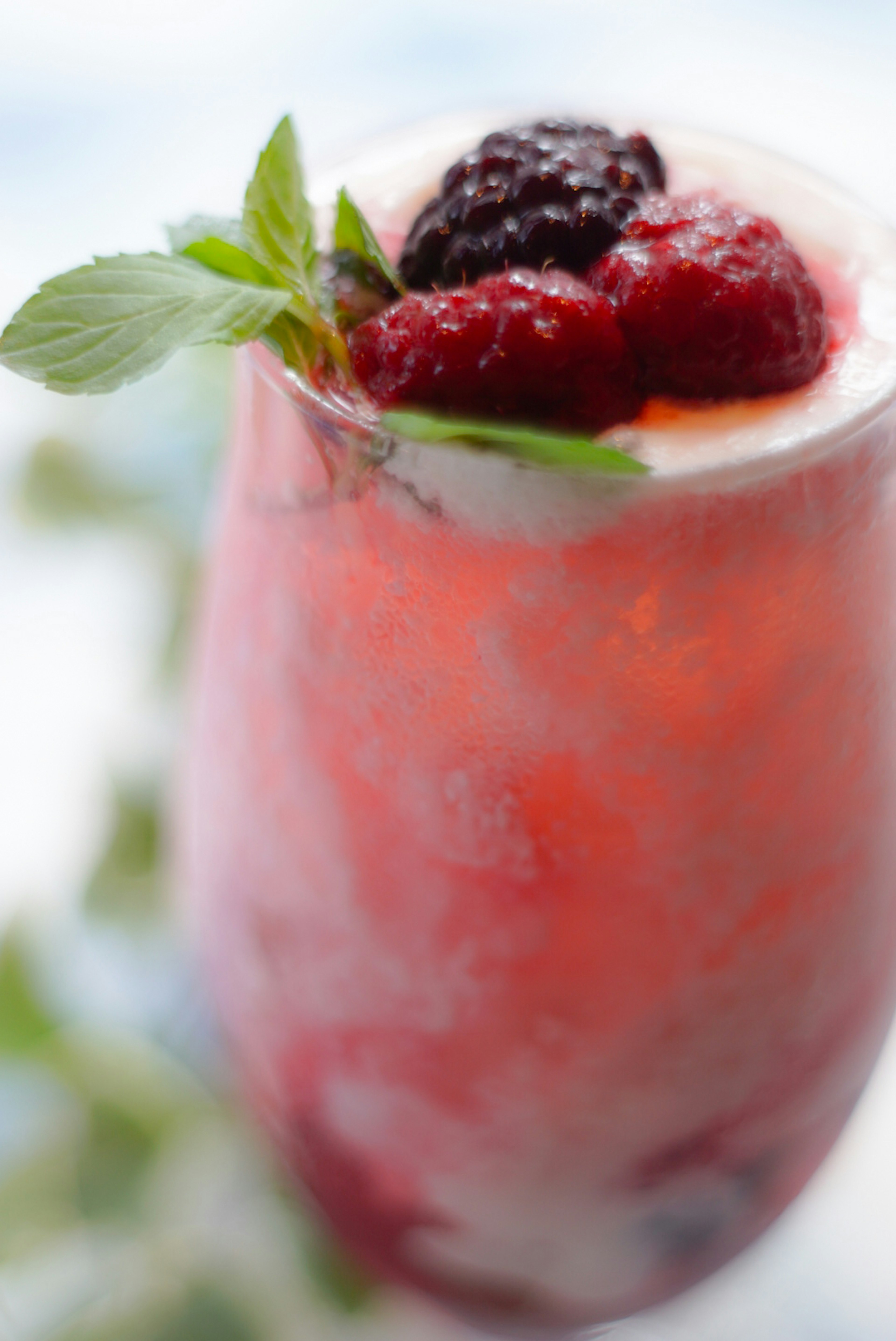 Close-up of a beautiful berry cocktail garnished with fresh mint and raspberries