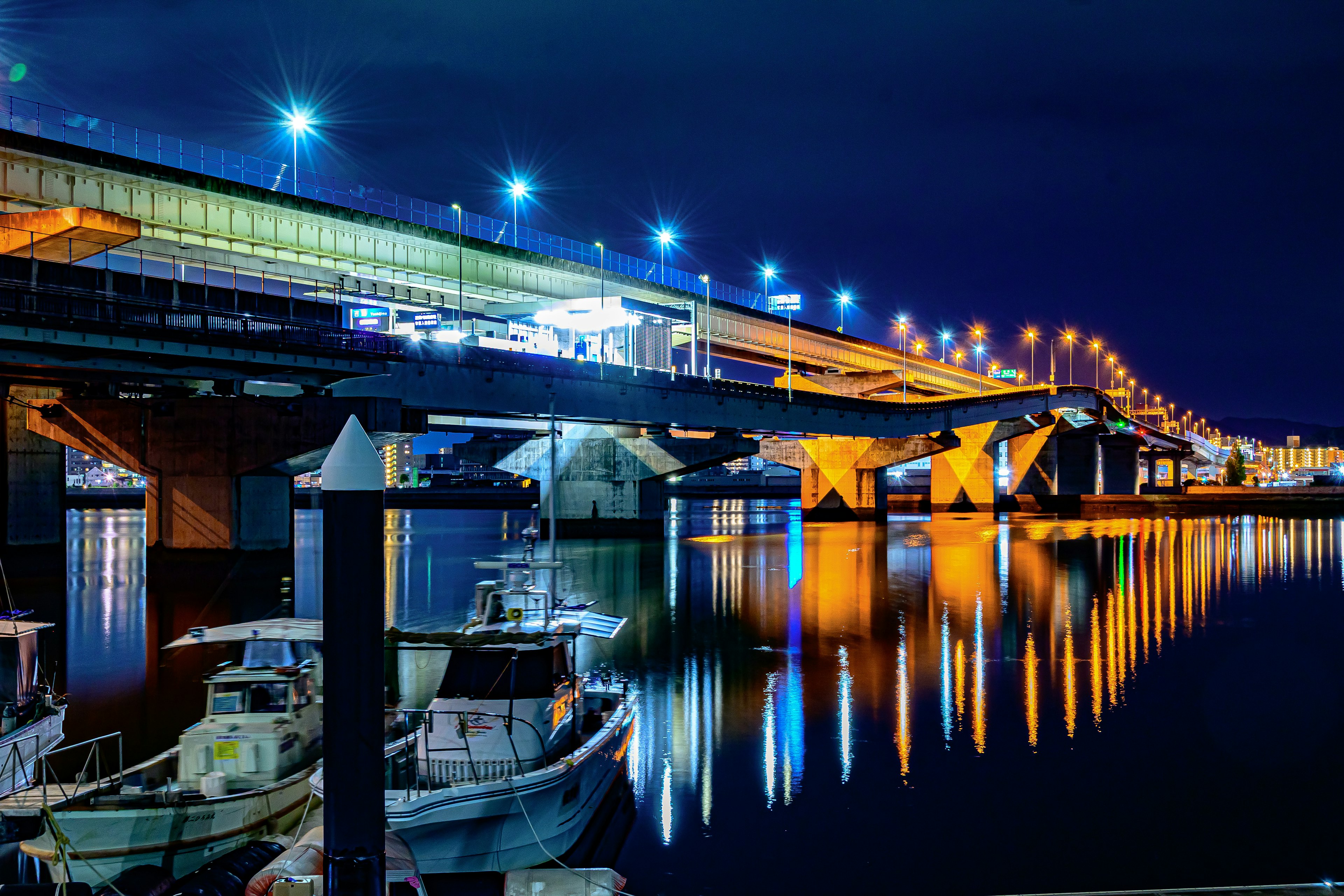 Bridge illuminated at night with reflections on the water