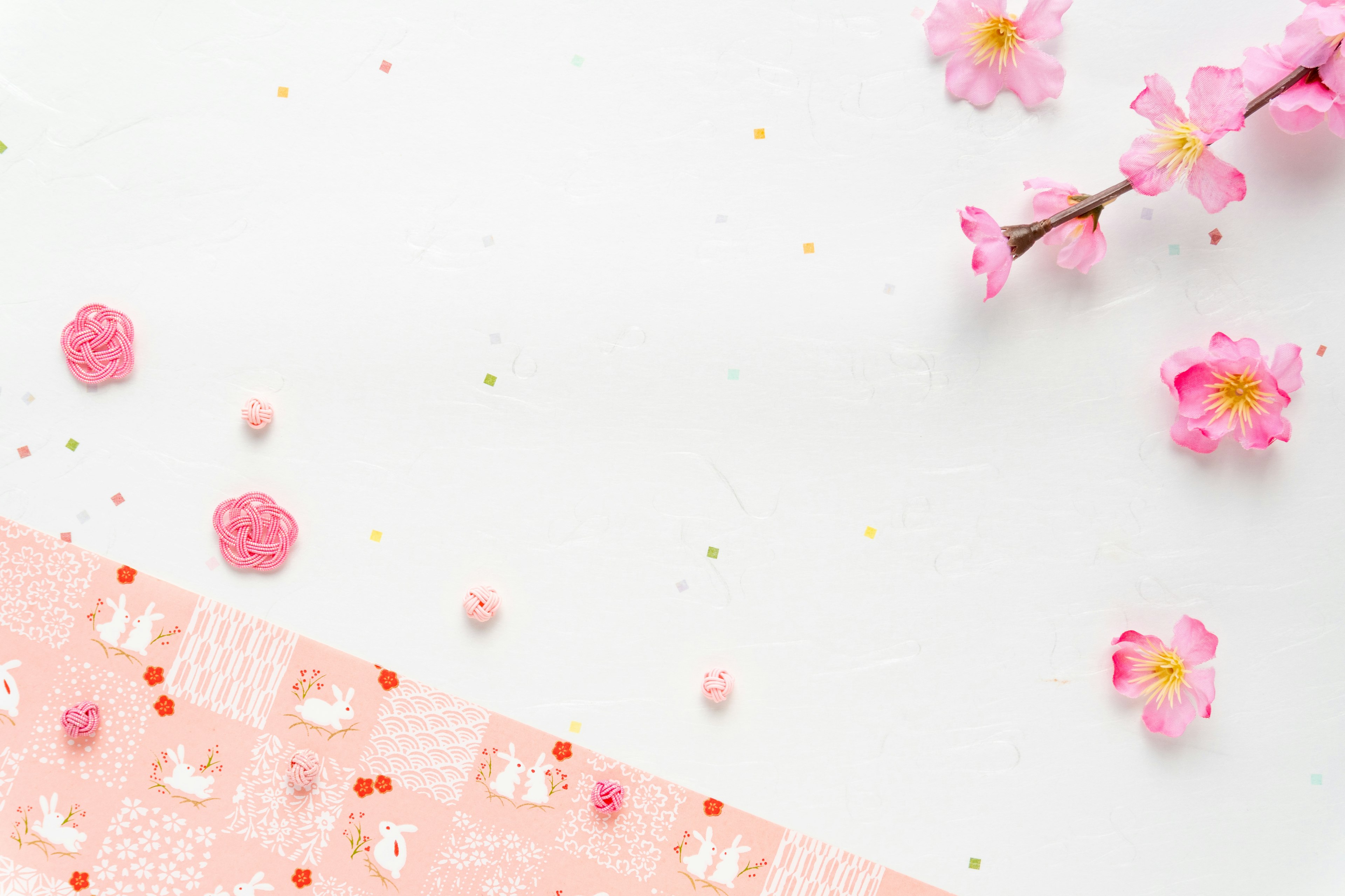 White background with scattered cherry blossom petals and pink decorations