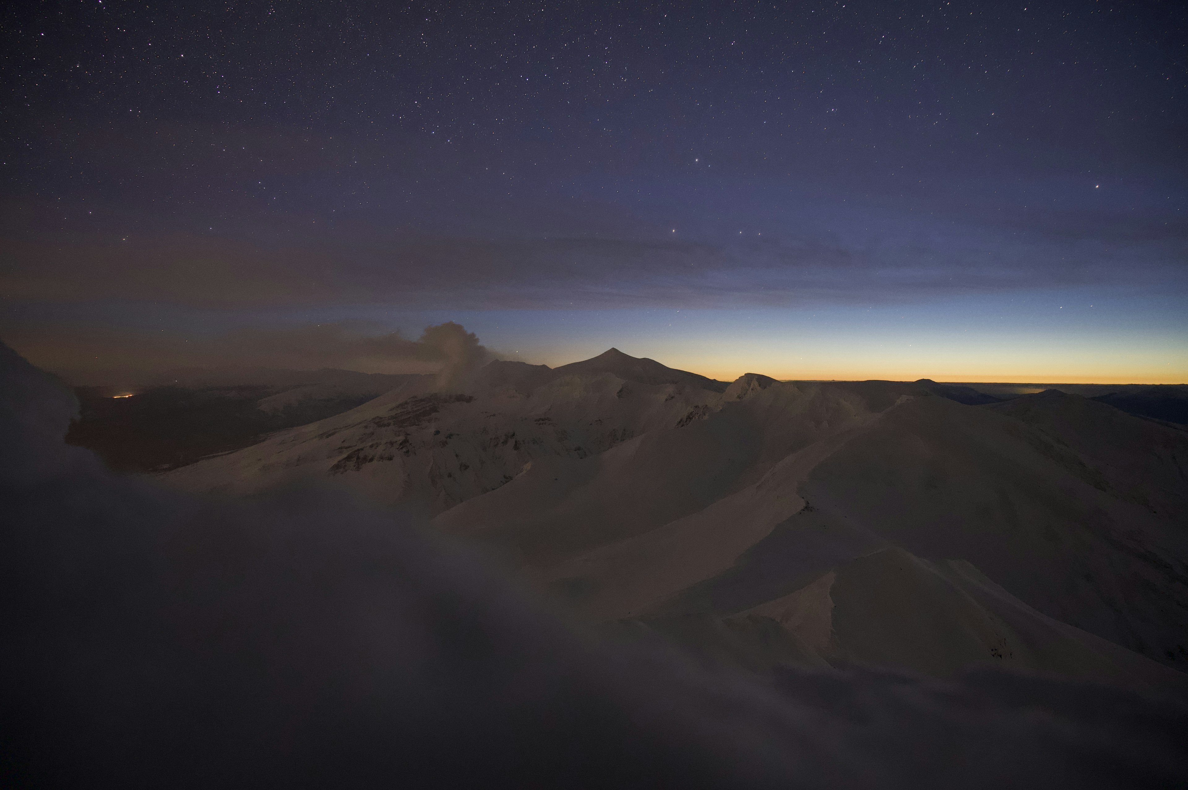 夜空の星々と山々のシルエットが映る美しい風景