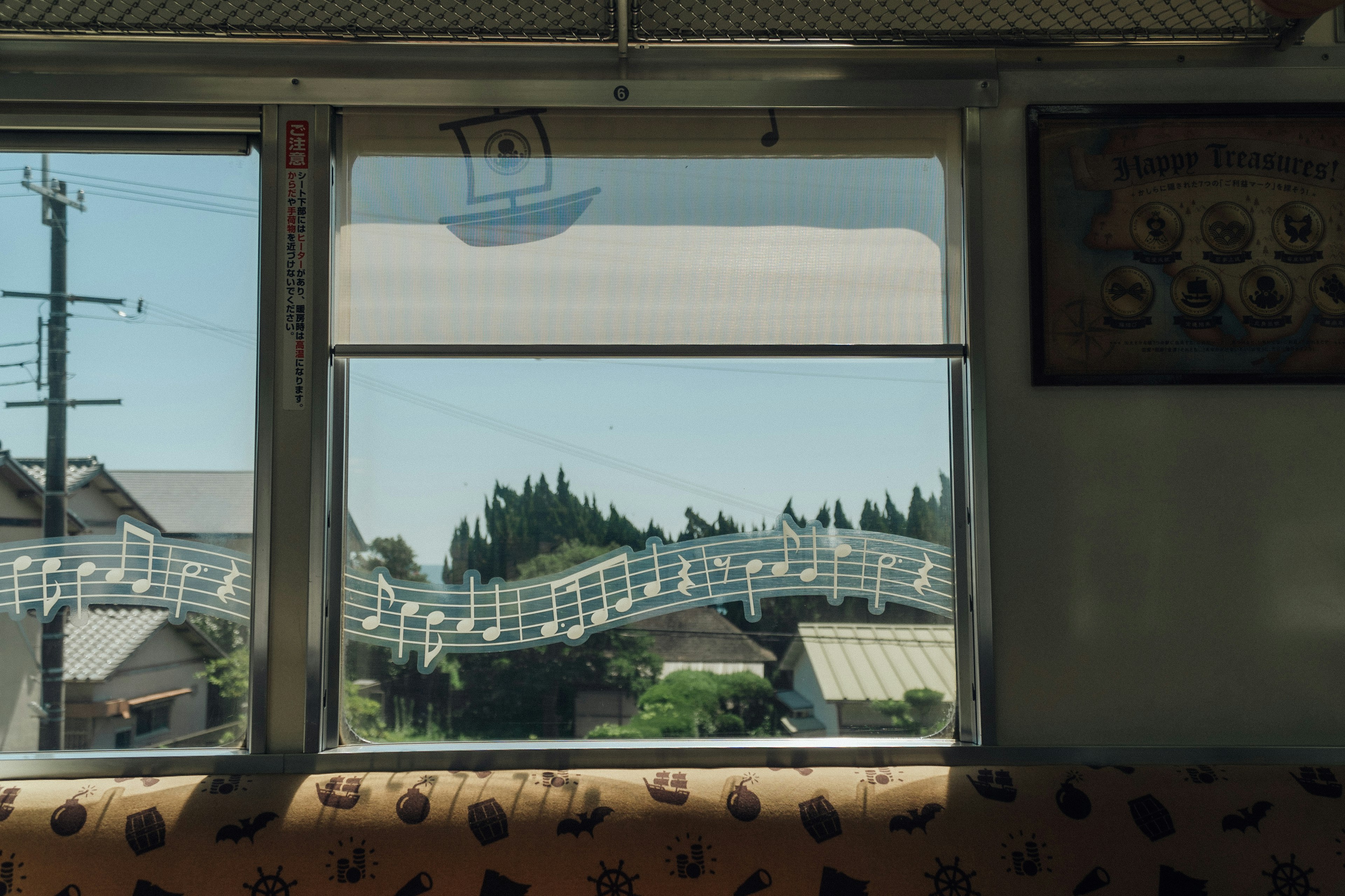 Vue d'une fenêtre de train montrant un pont en forme de note de musique et un paysage rural