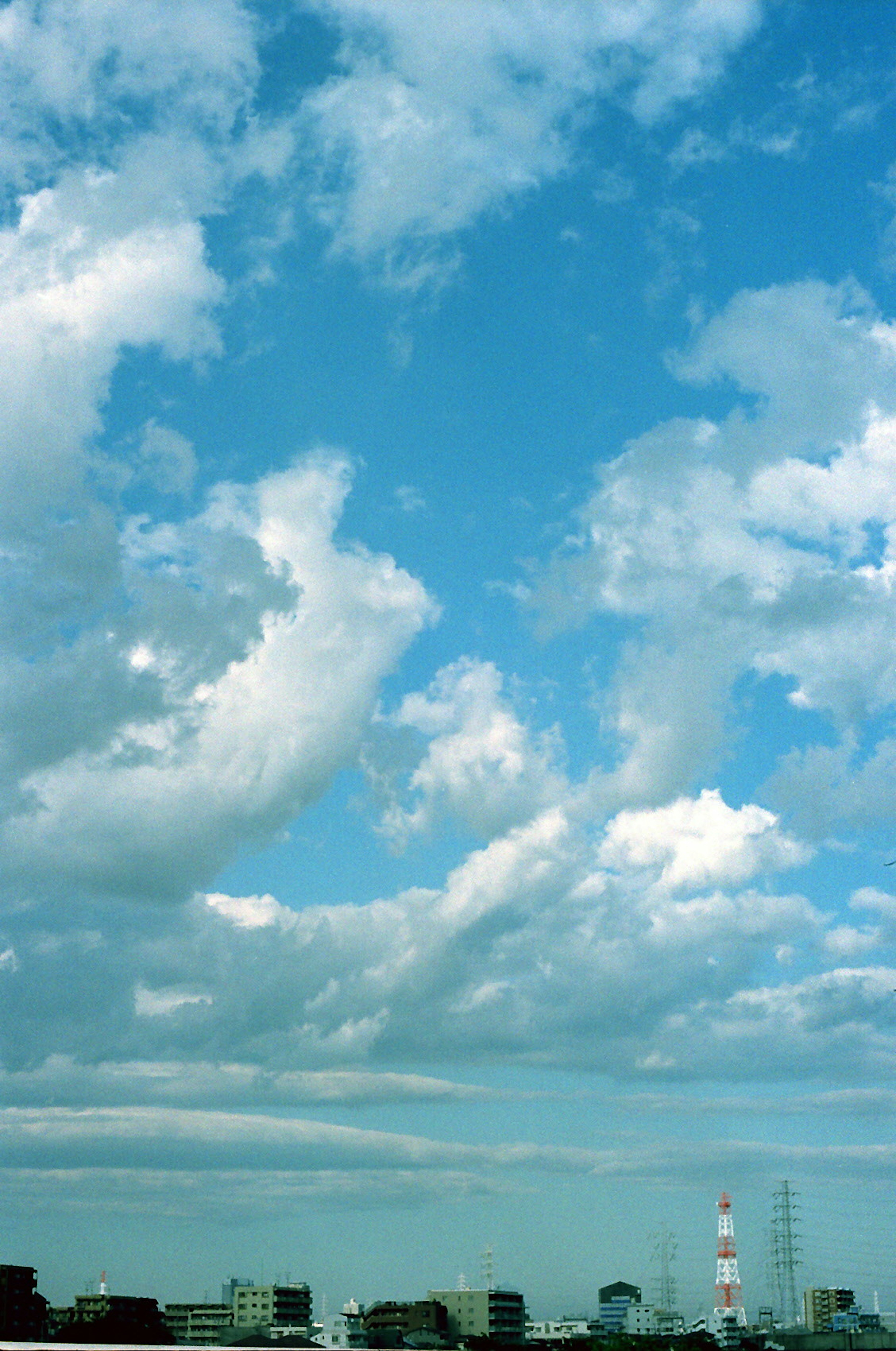 Ciel bleu avec des nuages blancs et silhouette de la ville