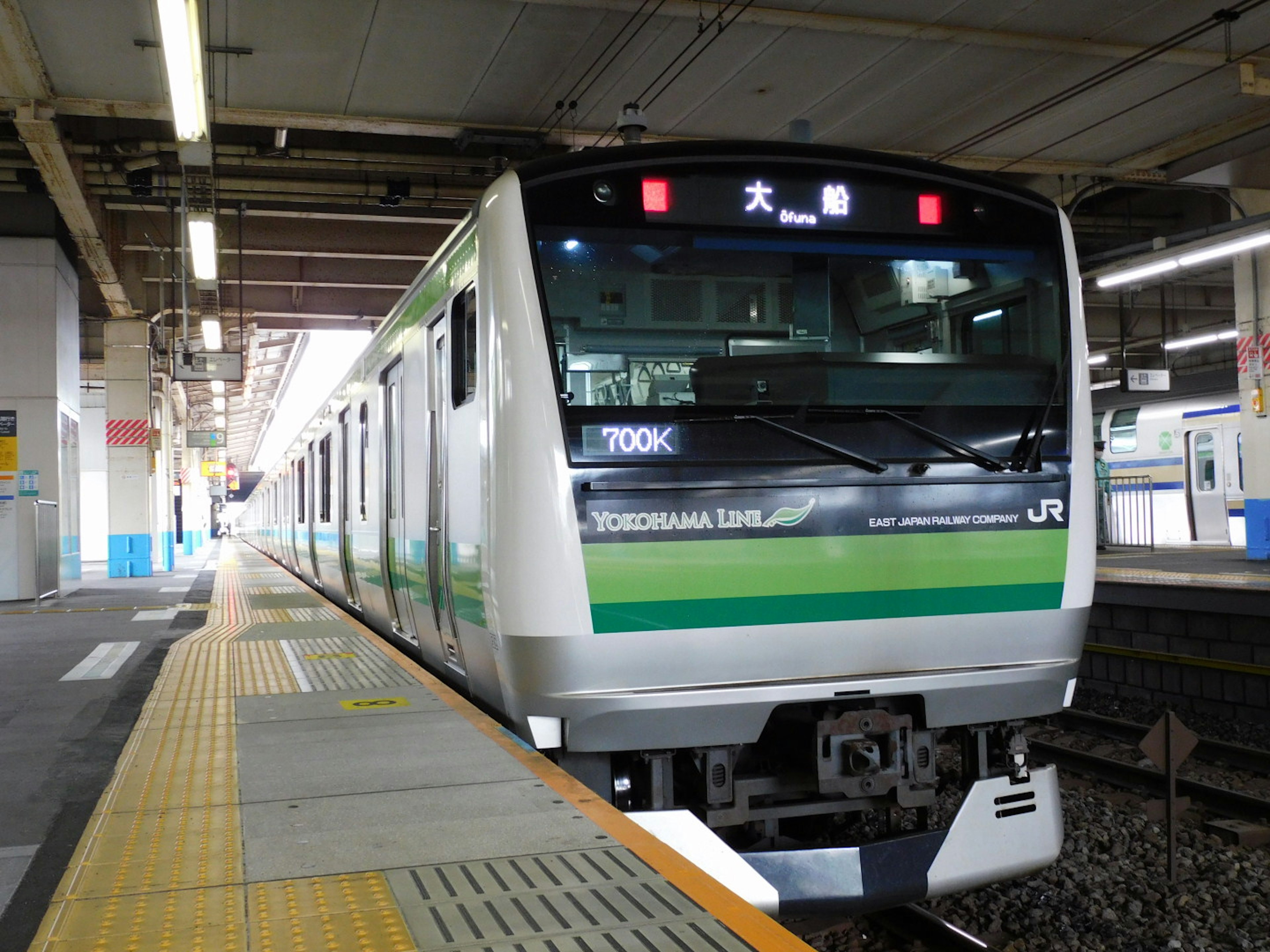 Kereta JR dengan garis hijau berhenti di stasiun