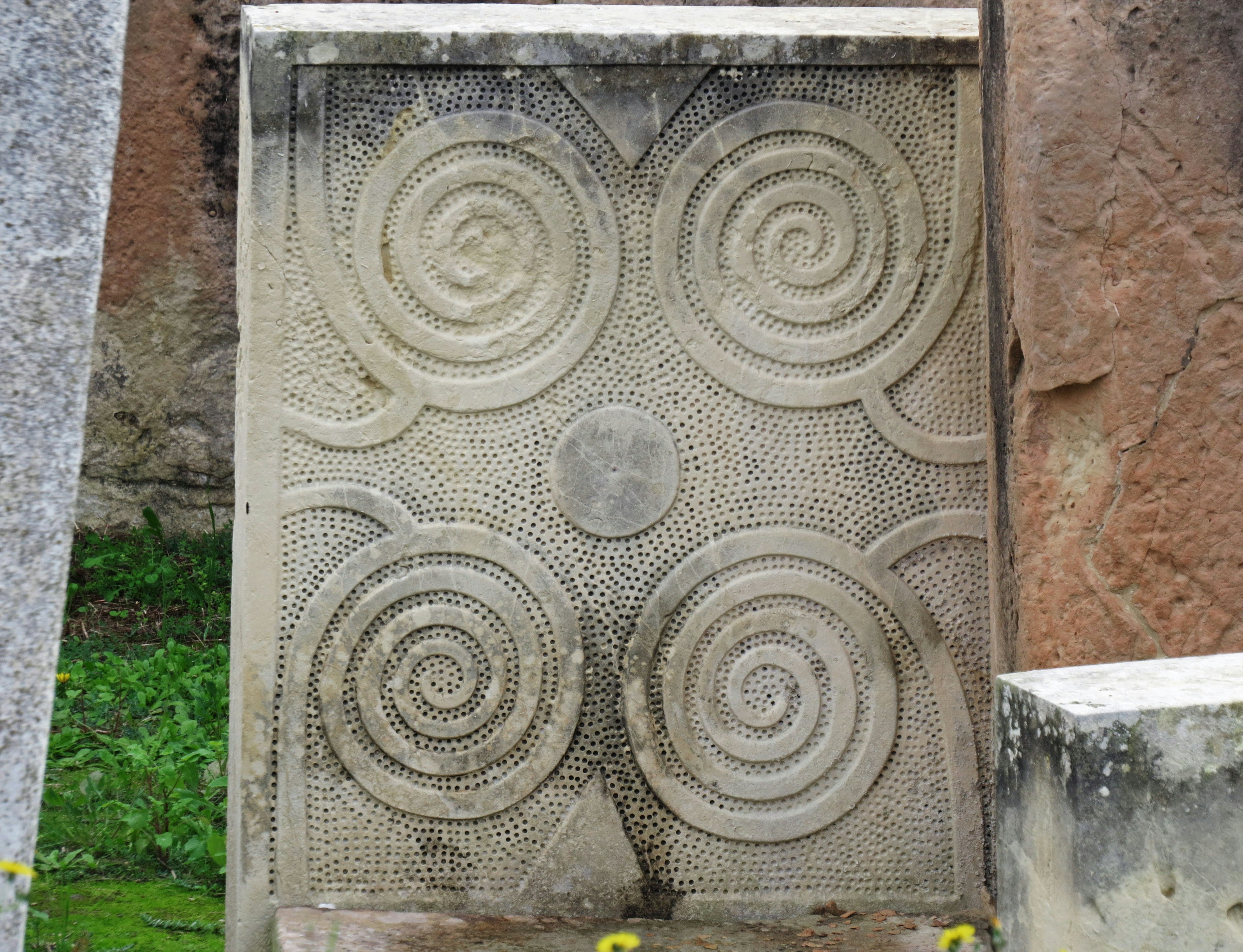 Dalle en pierre avec quatre motifs en spirale sculptés à la surface