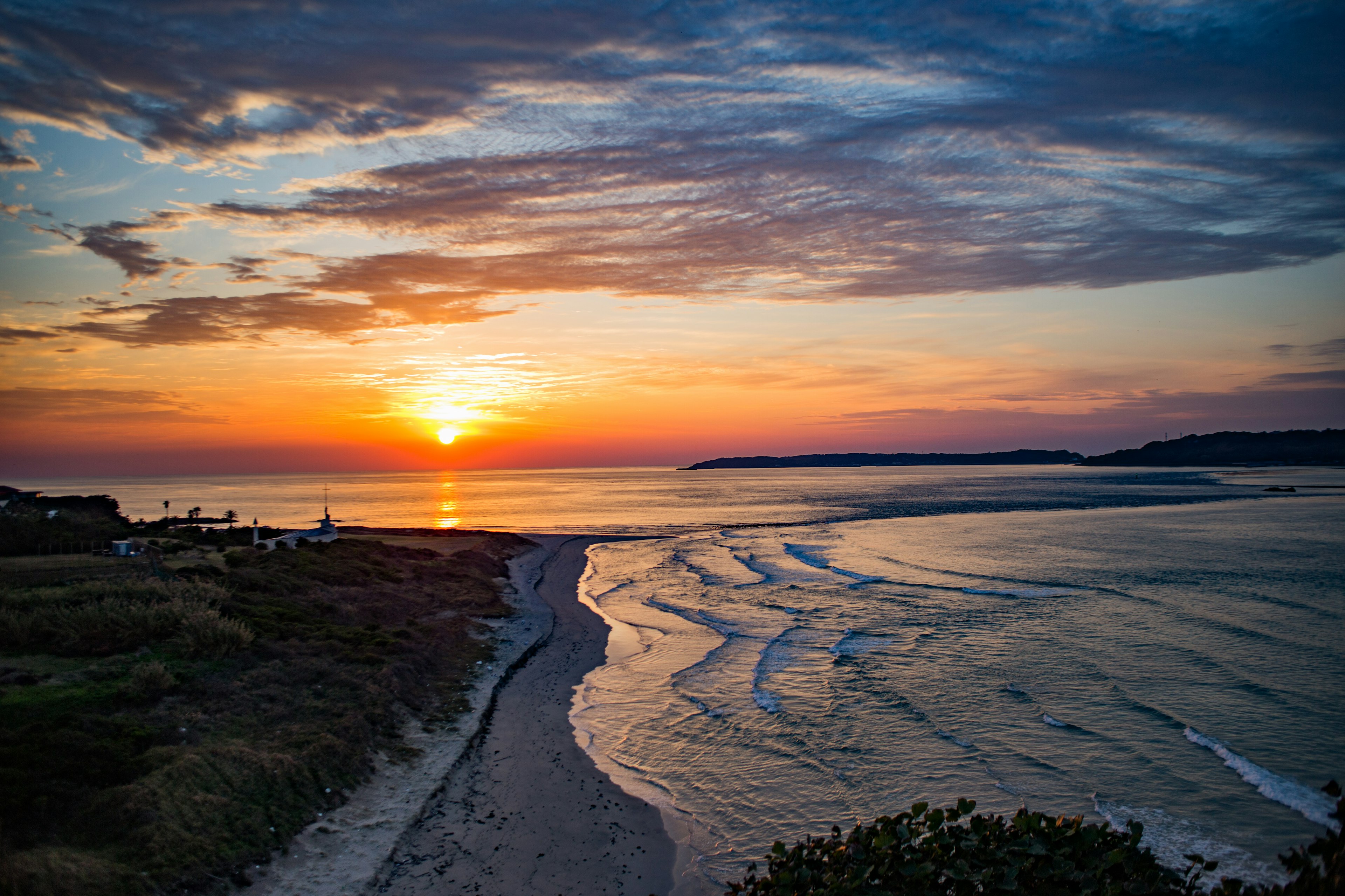 Sunset over the coastline with waves