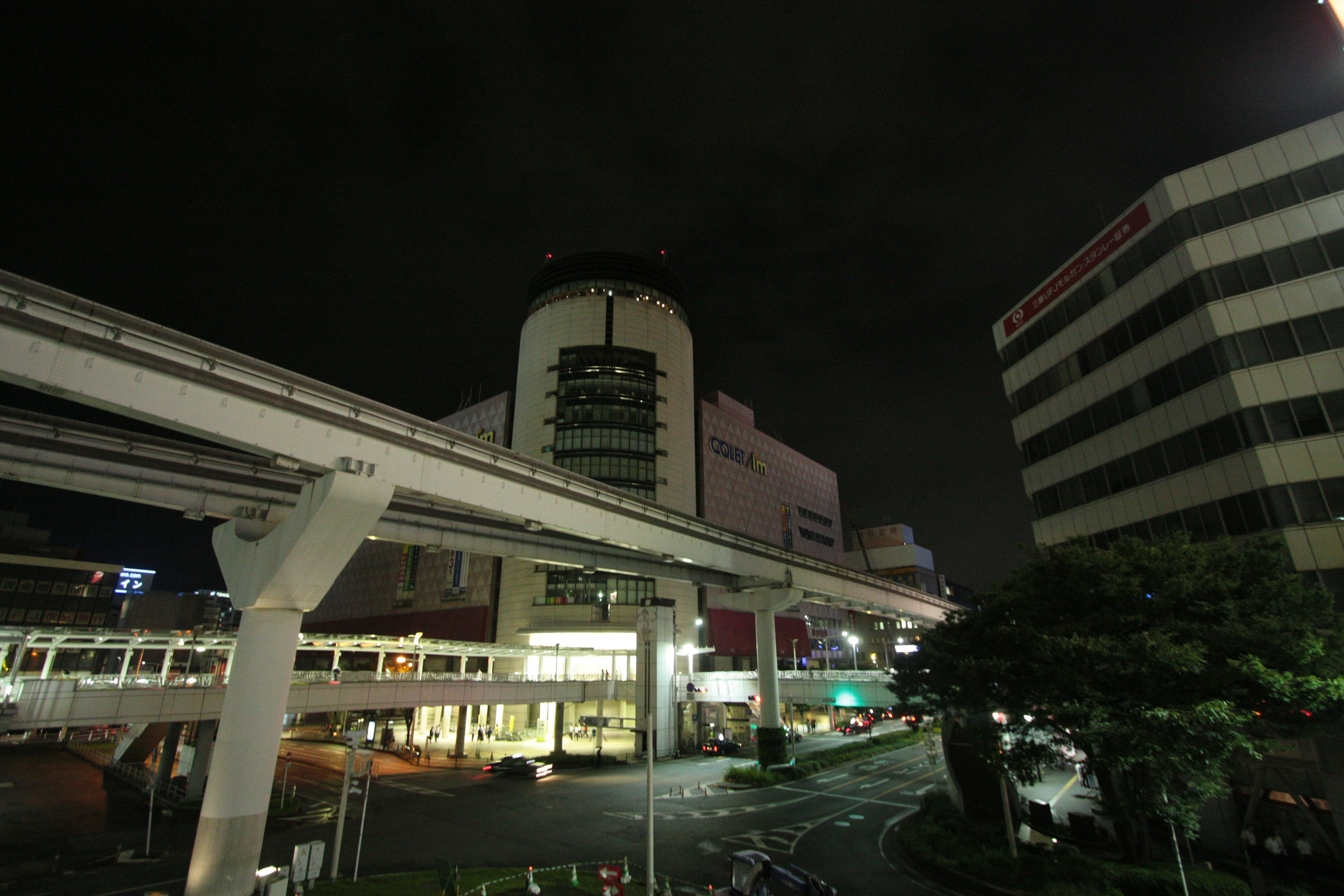 Nighttime cityscape featuring a monorail and buildings