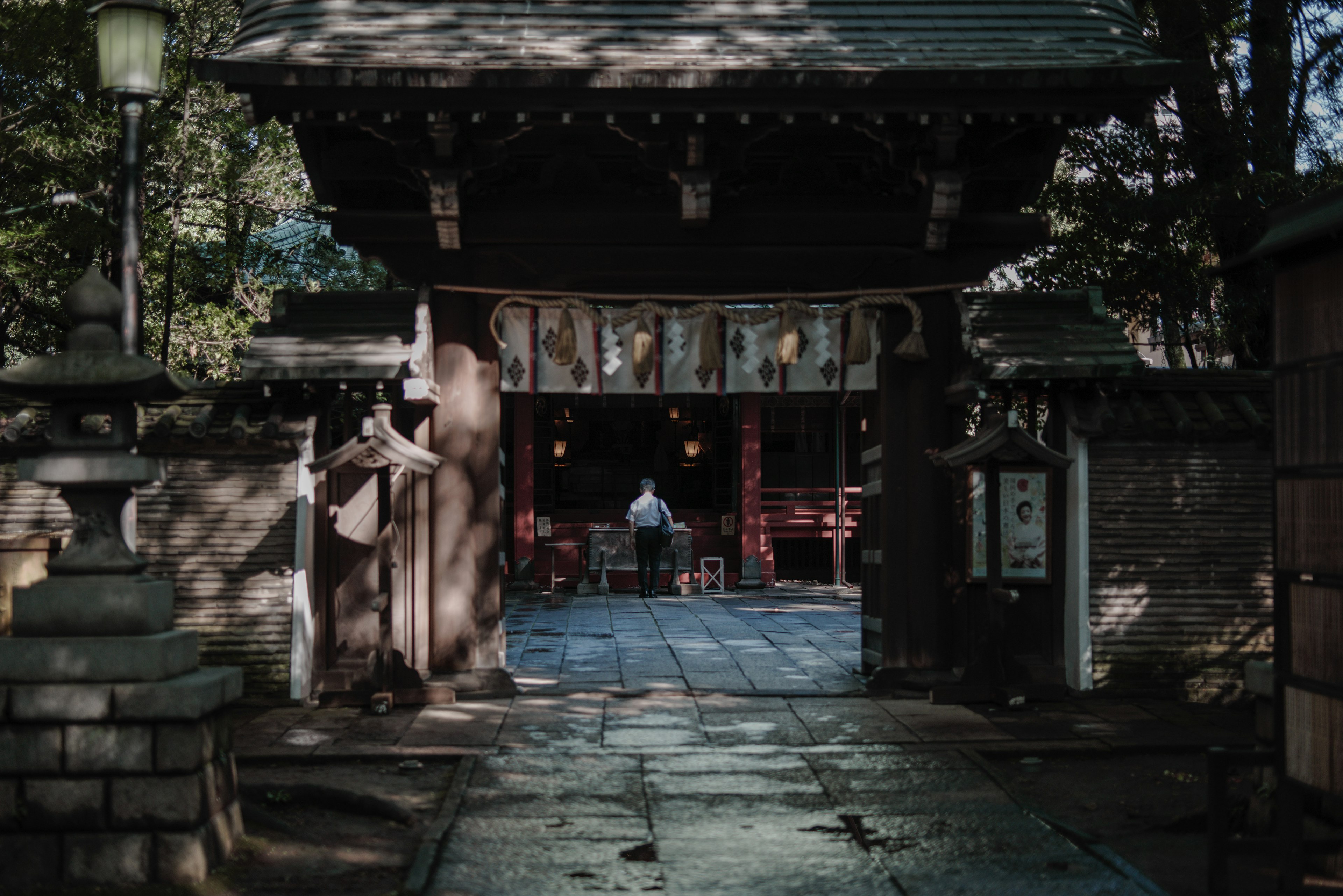 寧靜的神社門口，裡面有一個人坐著