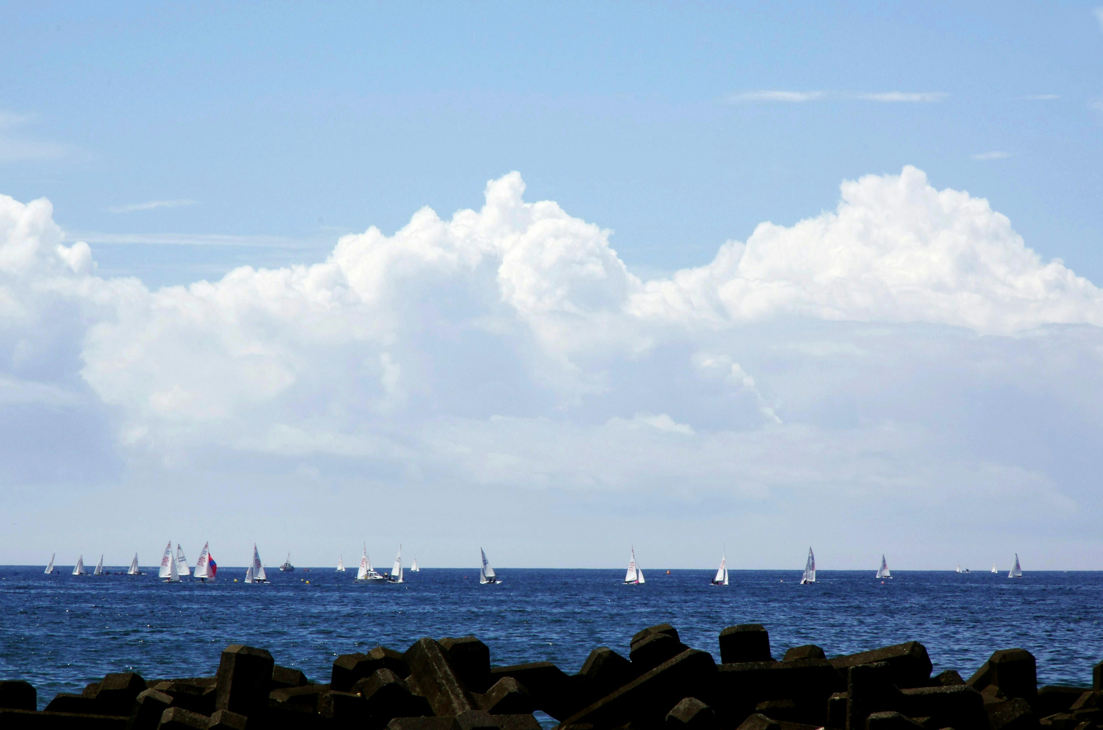 Voiliers sur une mer bleue avec des nuages blancs dans le ciel