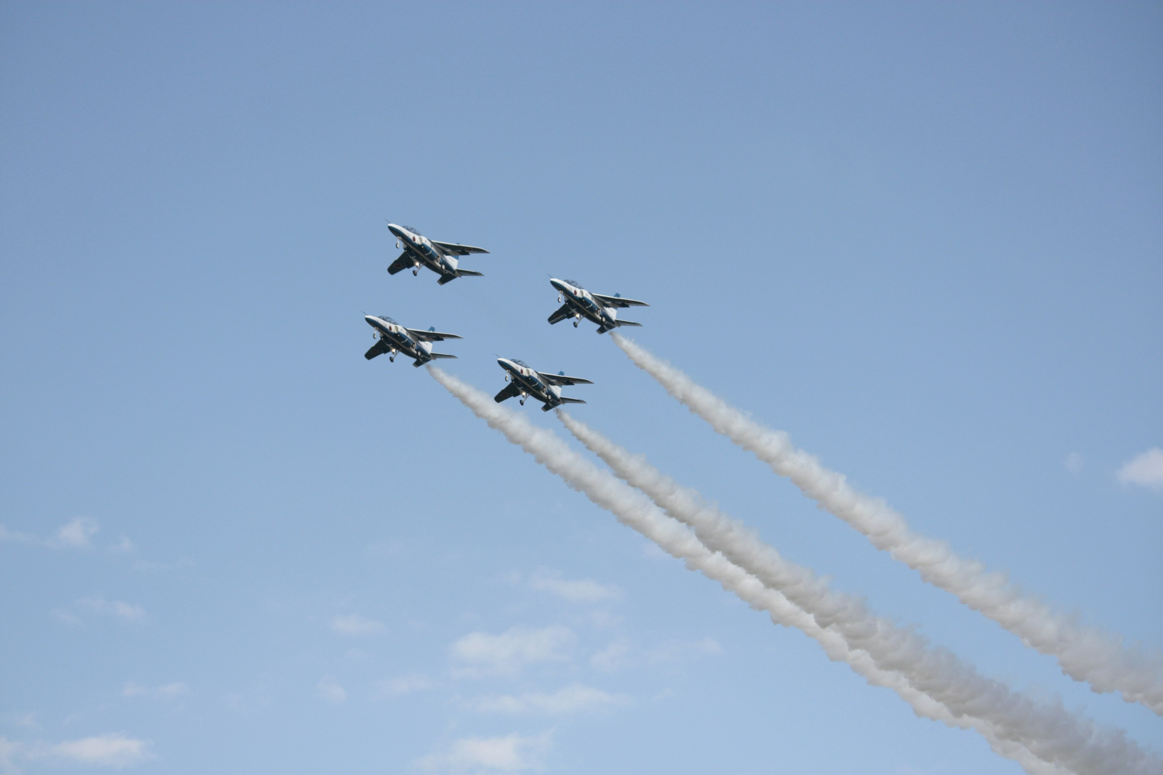 Formation of four fighter jets flying in the blue sky