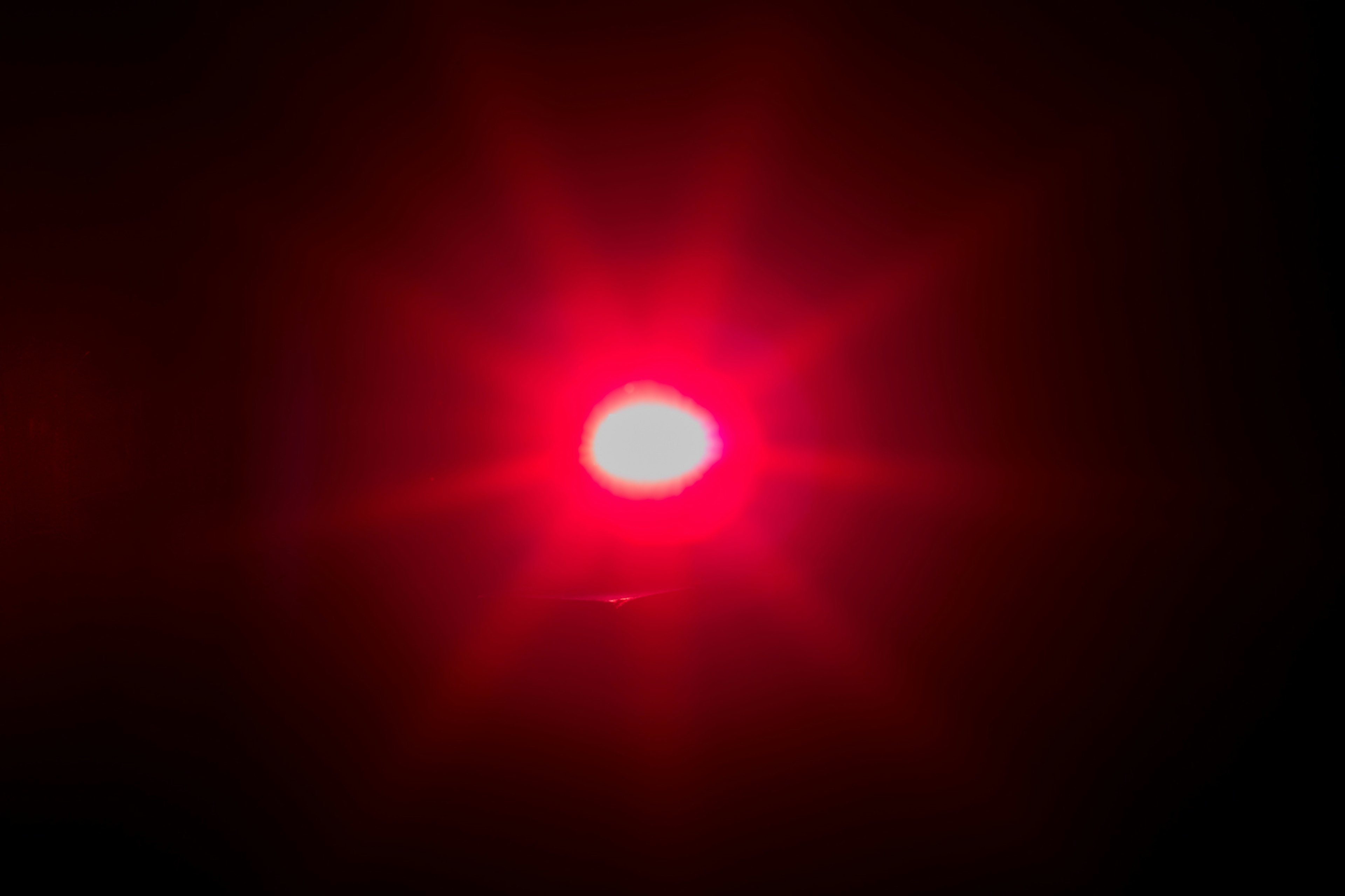 Red star-shaped light source in darkness