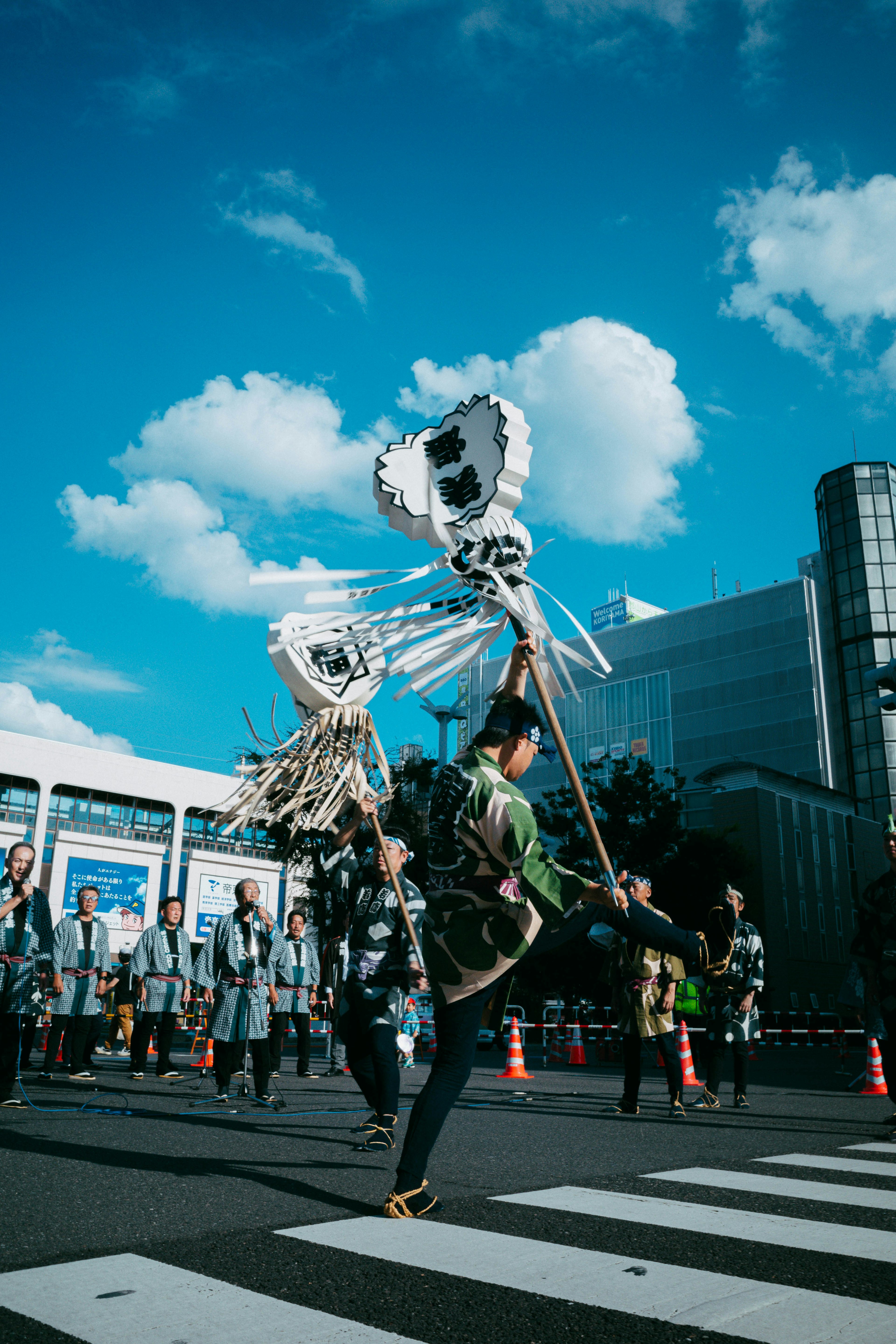 祭りの衣装を着た人が踊りながら伝統的な楽器を持っている街の風景