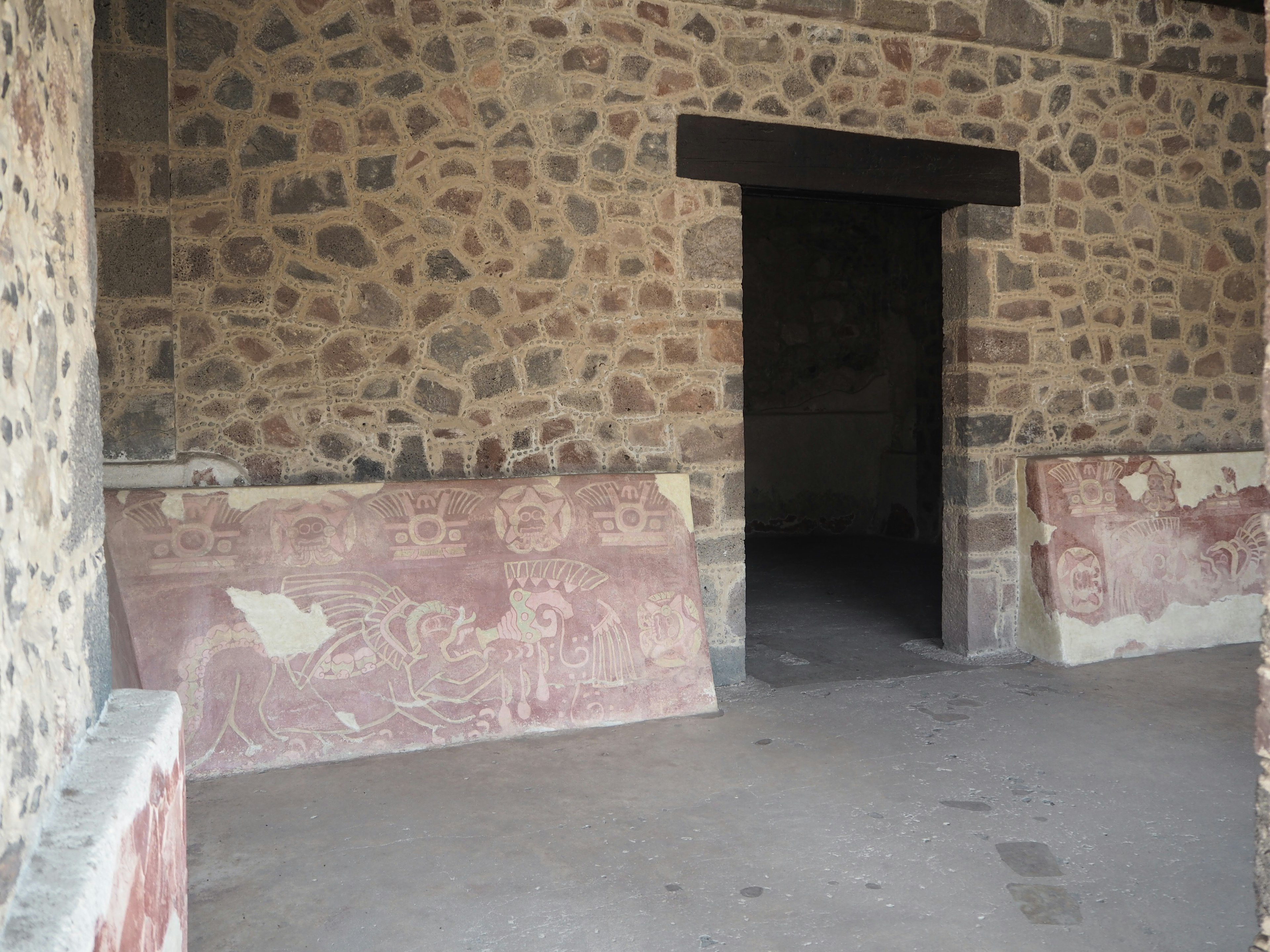 Intérieur d'une pièce avec des murs en pierre et une porte ouverte