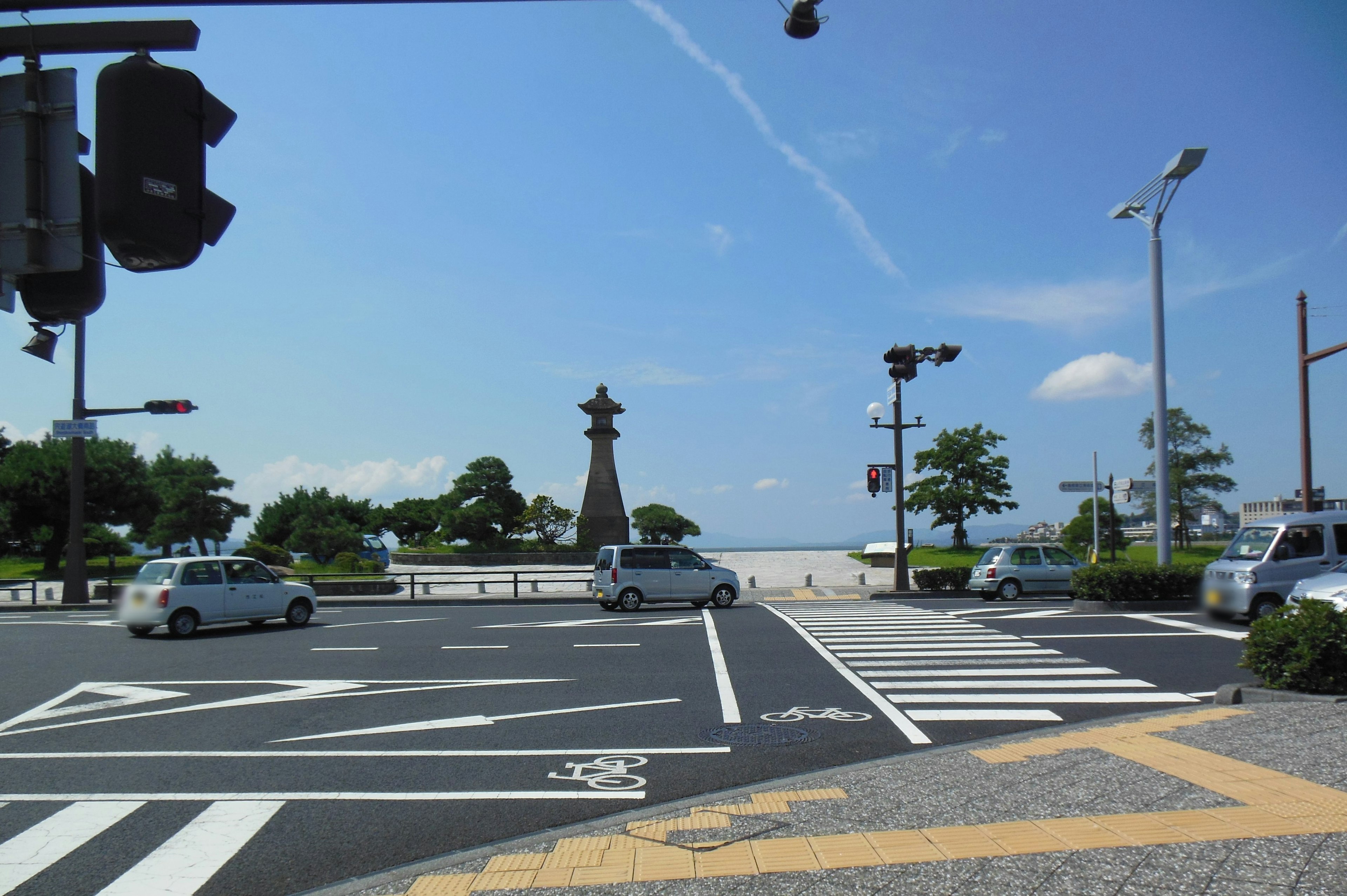 Kreuzung mit Blick auf den Strand unter blauem Himmel Ampeln und Autos sichtbar