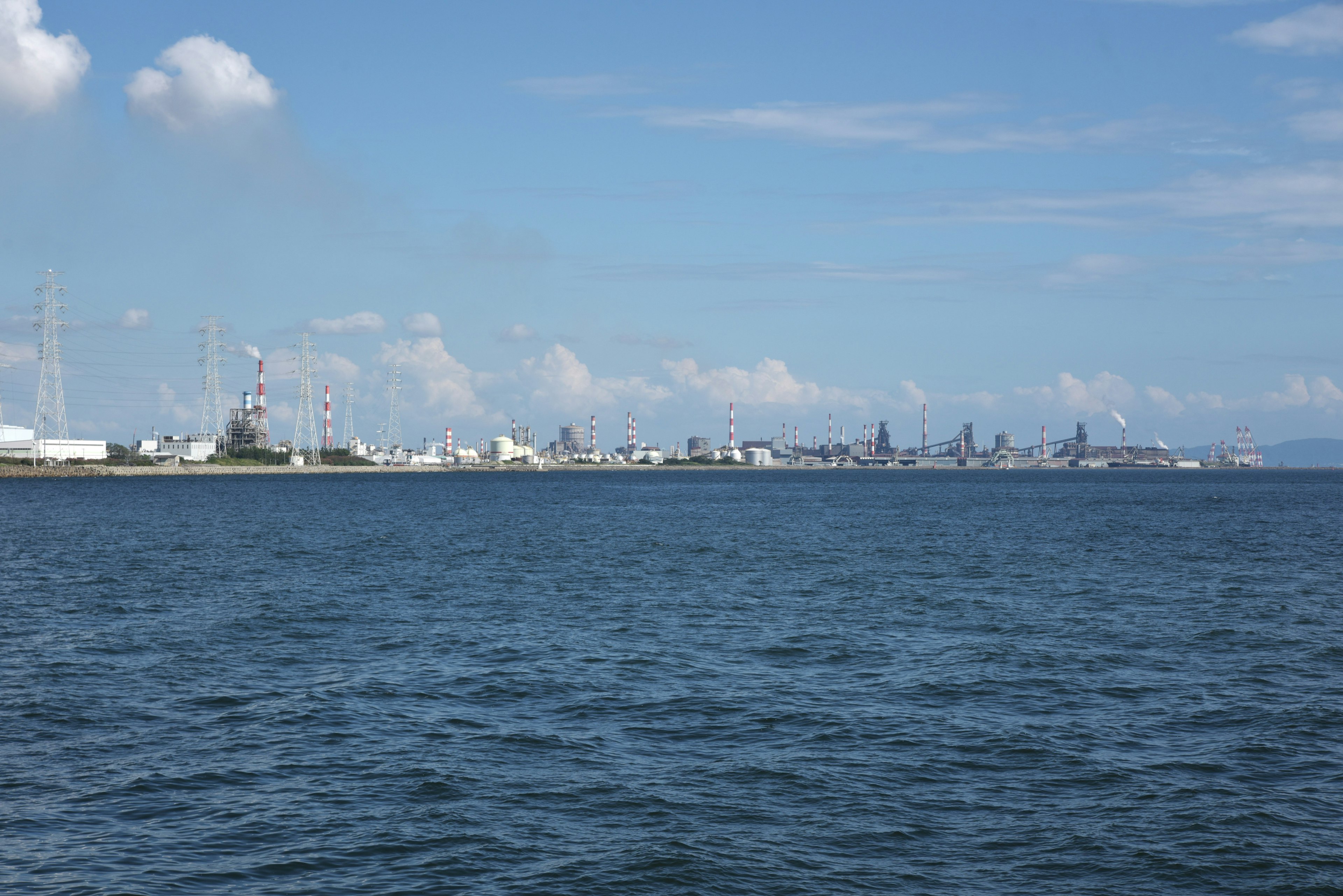 Coastal city skyline under blue sky with calm waters