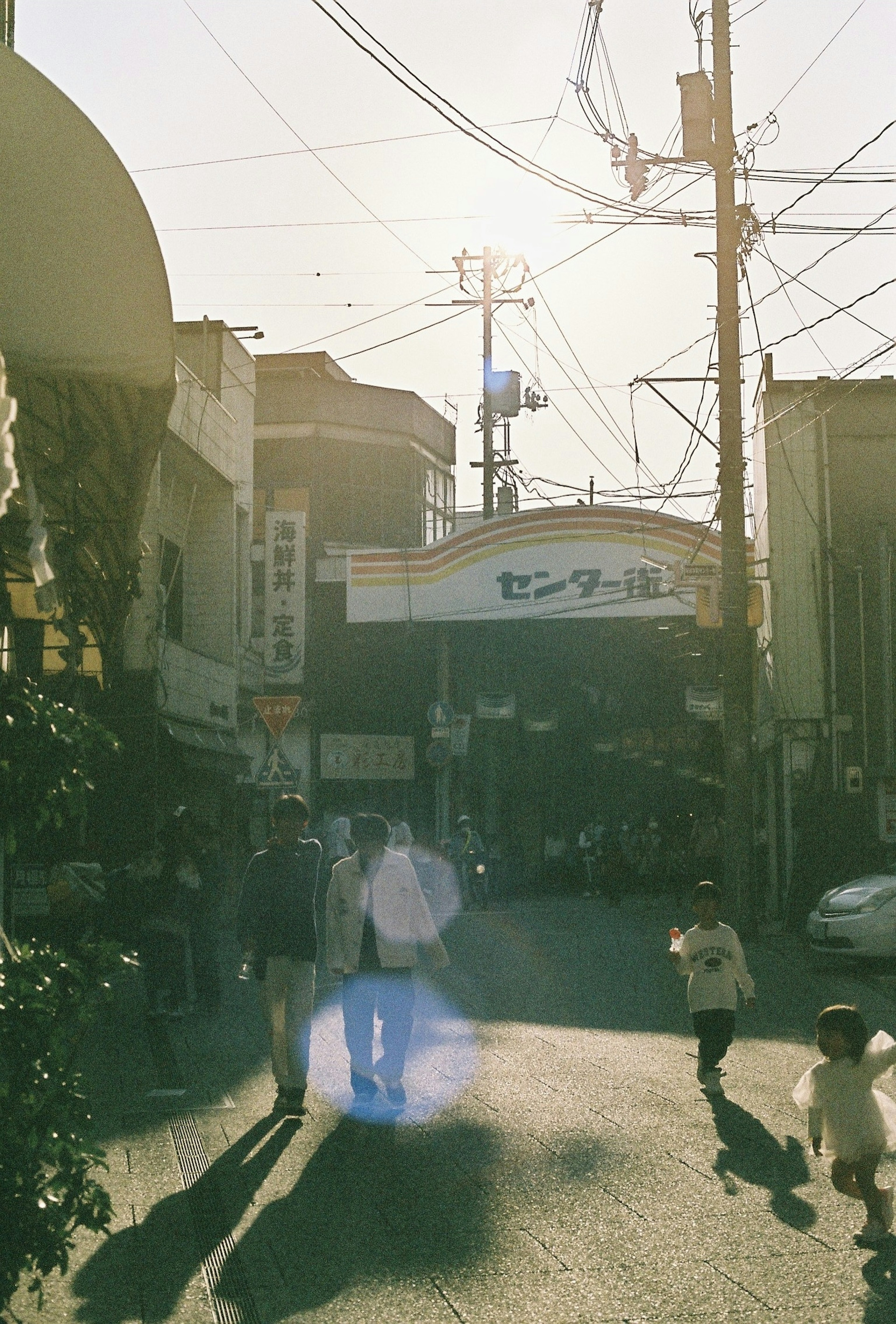 Street scene with people walking in a sunlit shopping district