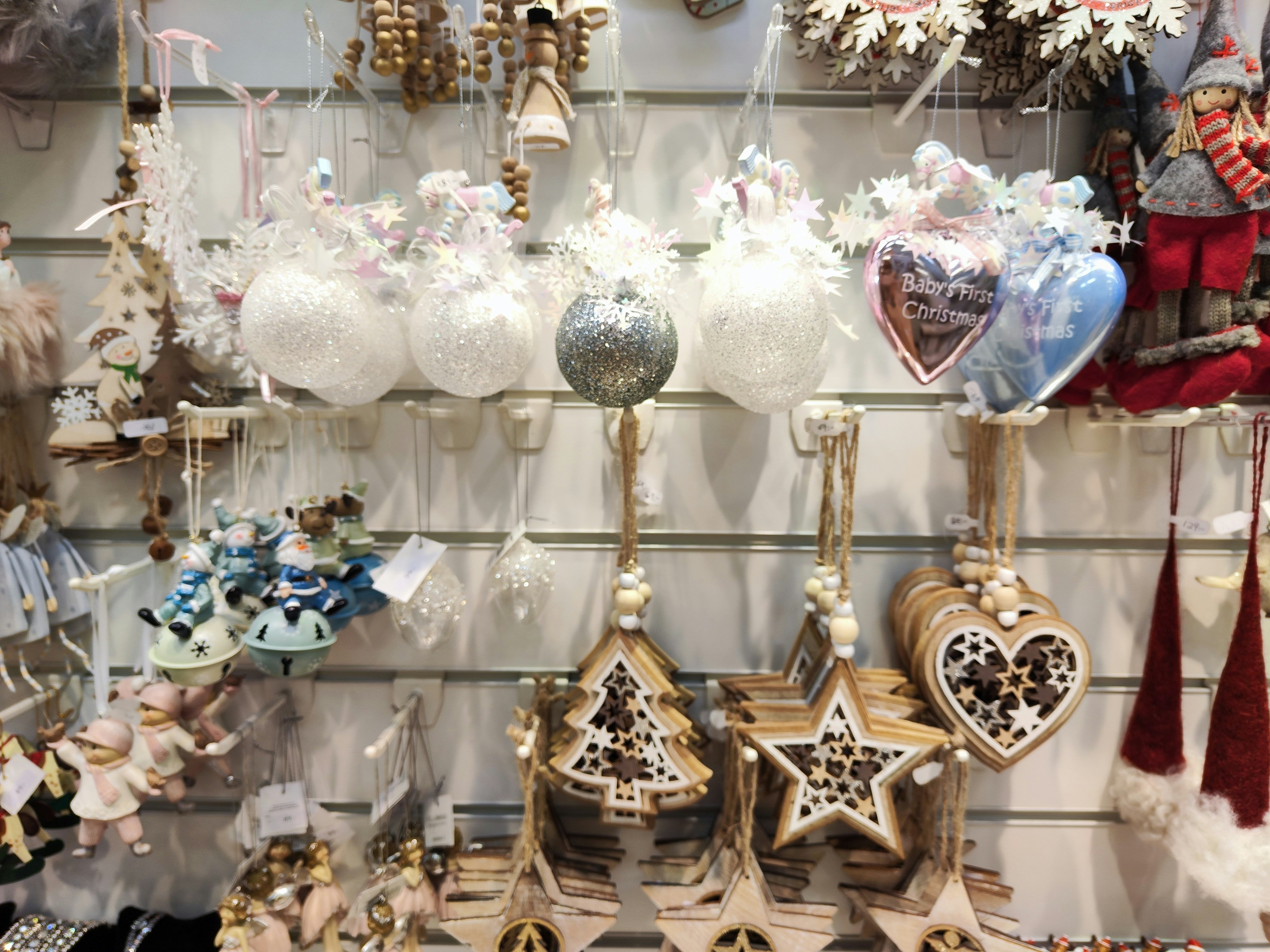 Ornements de Noël décoratifs en blanc et bleu ainsi que des décorations en bois exposées dans un magasin