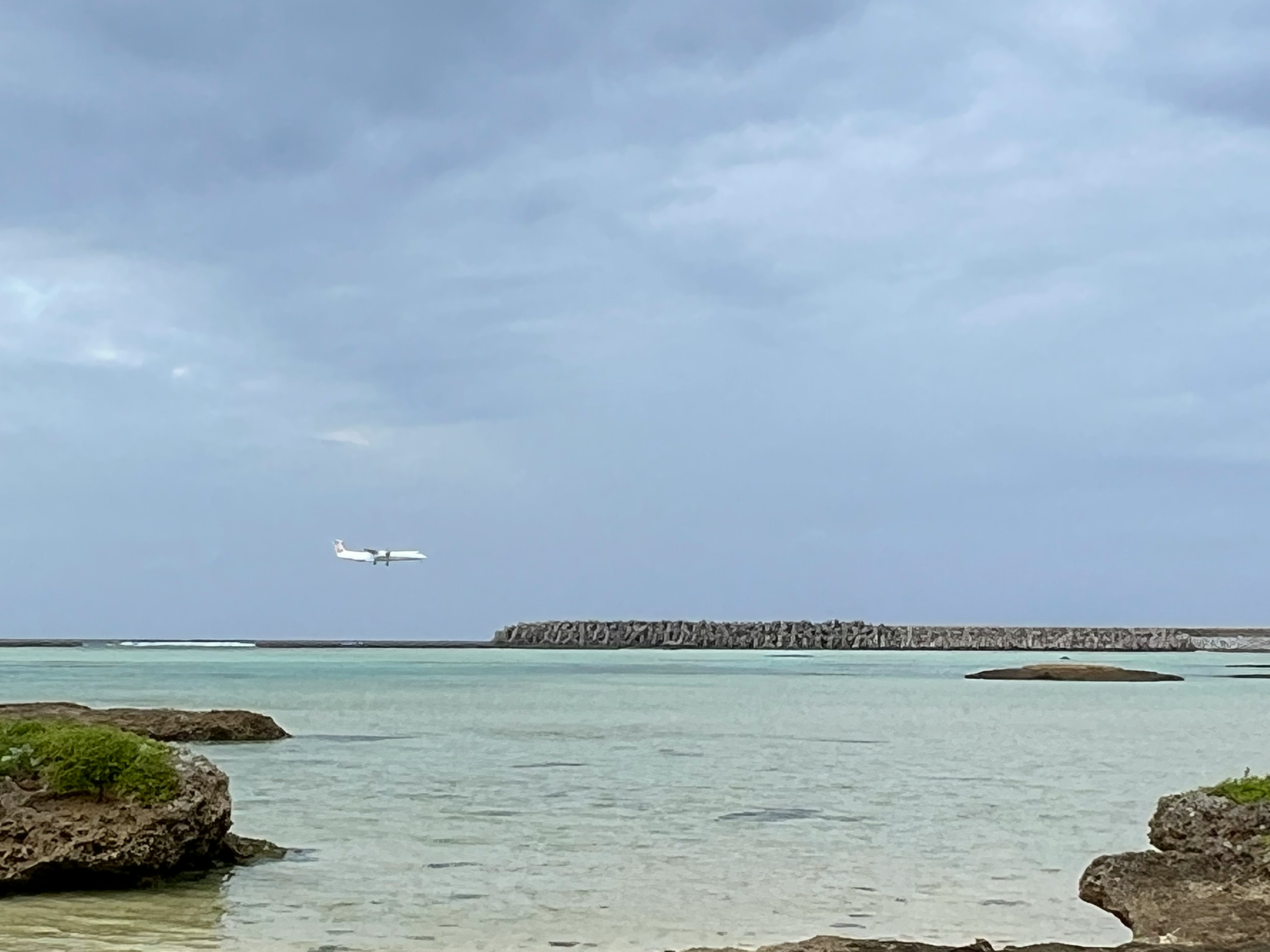 海の上を飛ぶ飛行機と静かな水面の風景