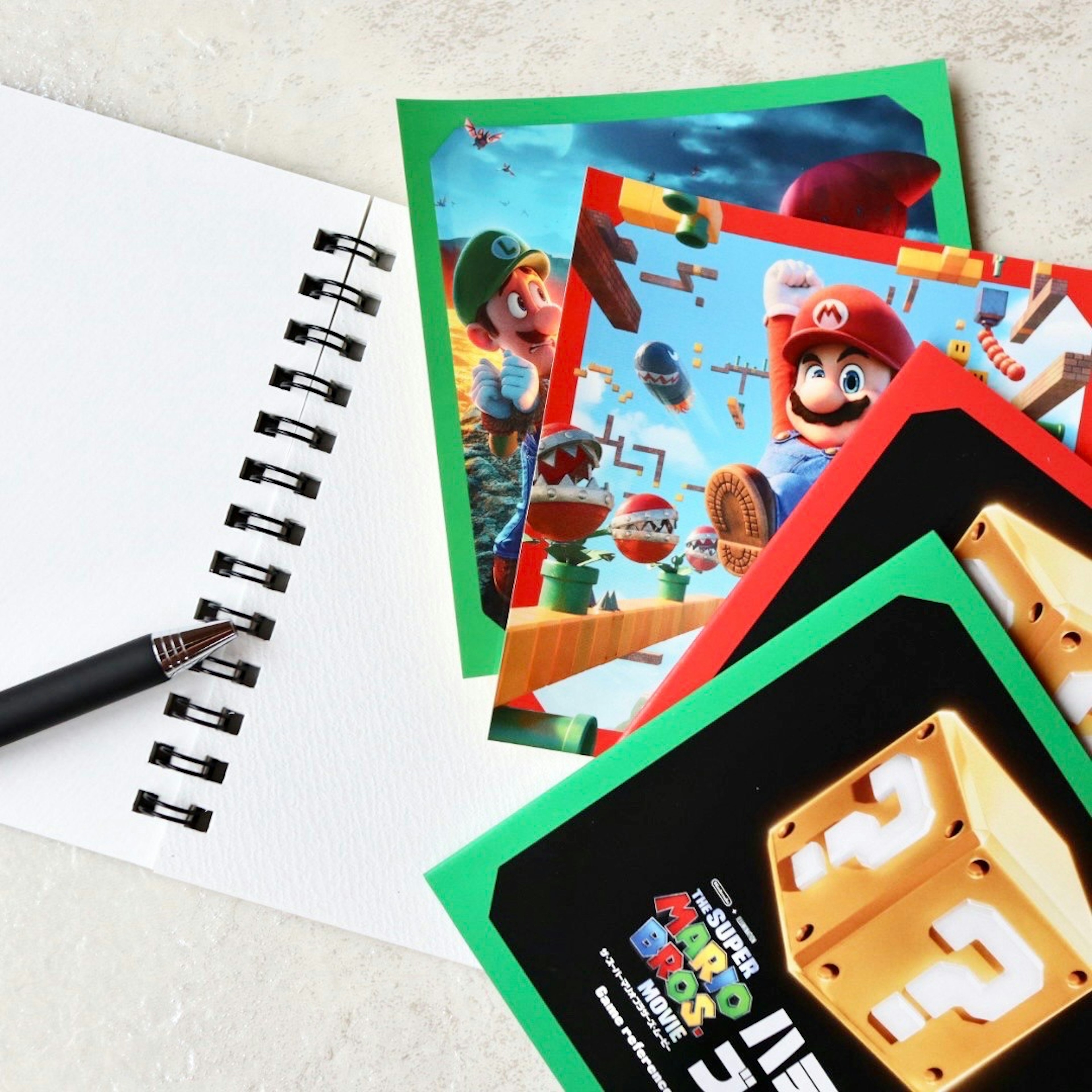 Tarjetas con temática de Super Mario y un cuaderno con un bolígrafo