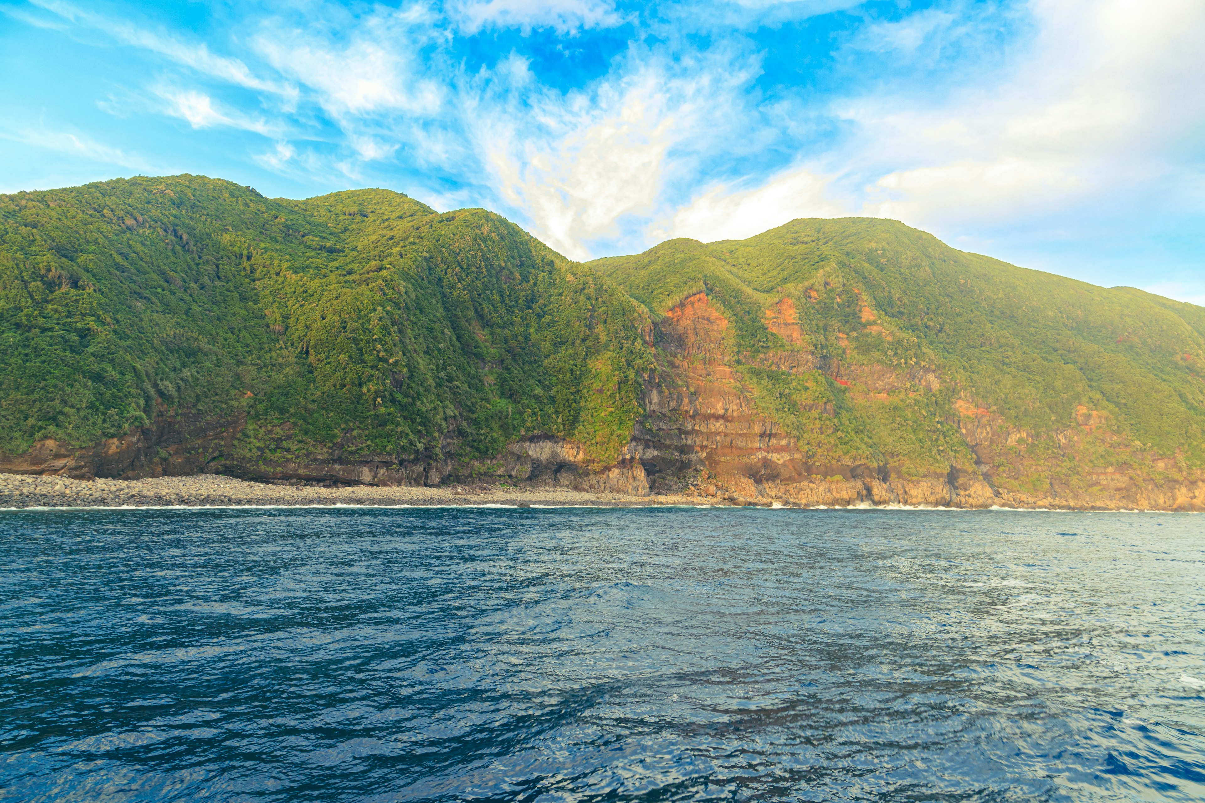 青い海と緑の山々の風景 明るい空と雲が広がる