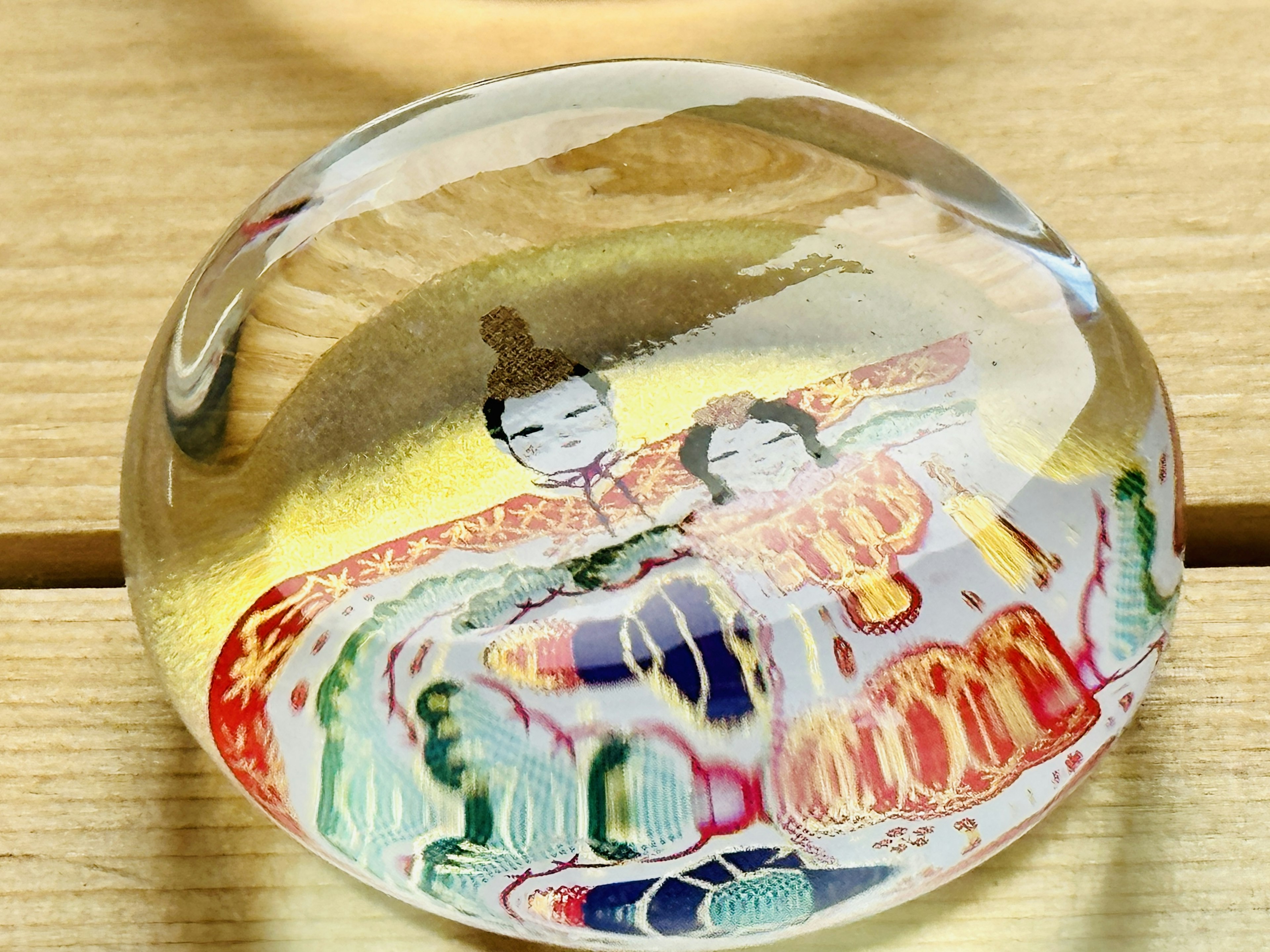 A transparent round object featuring traditional Japanese designs of two figures