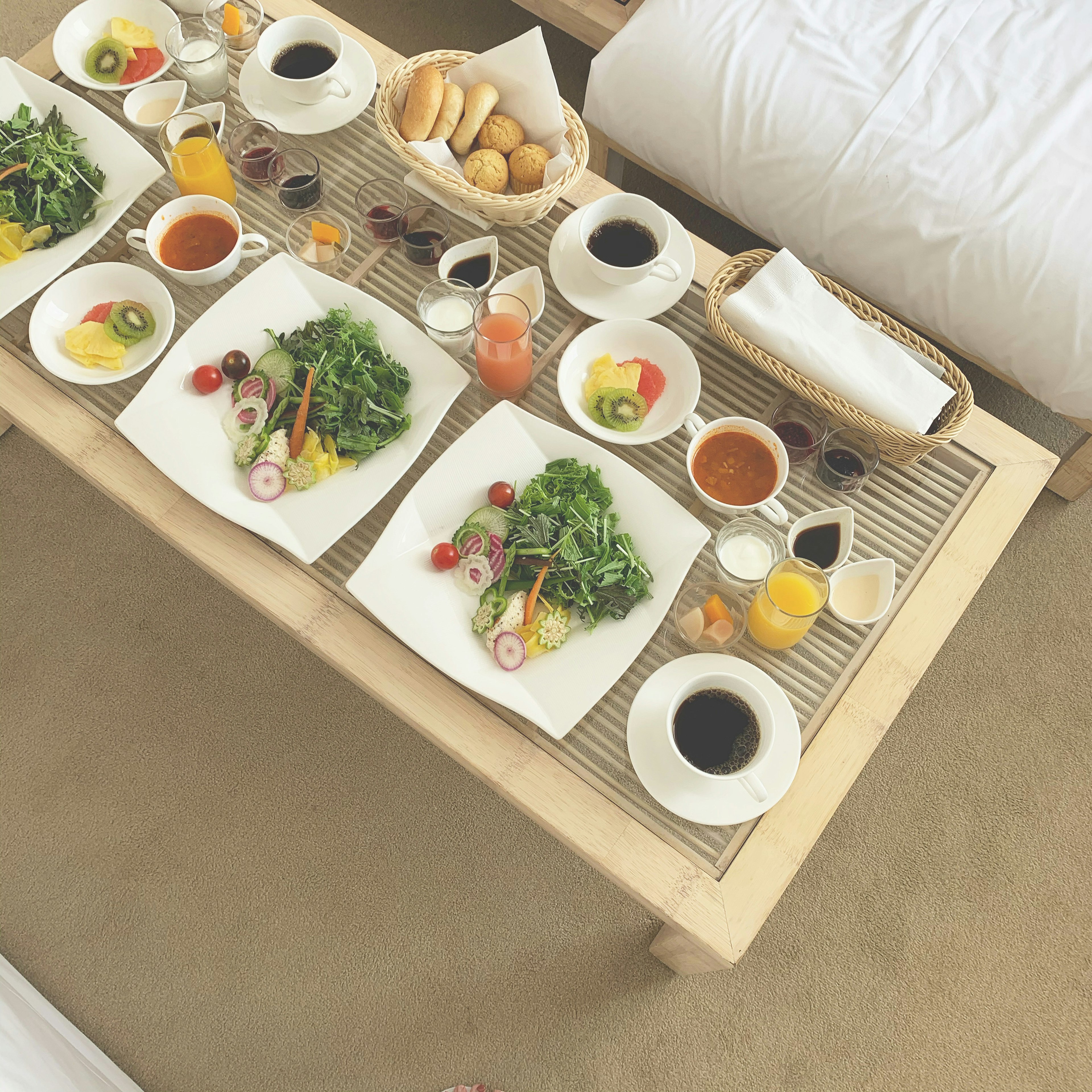 Breakfast table featuring salads, drinks, and pastries