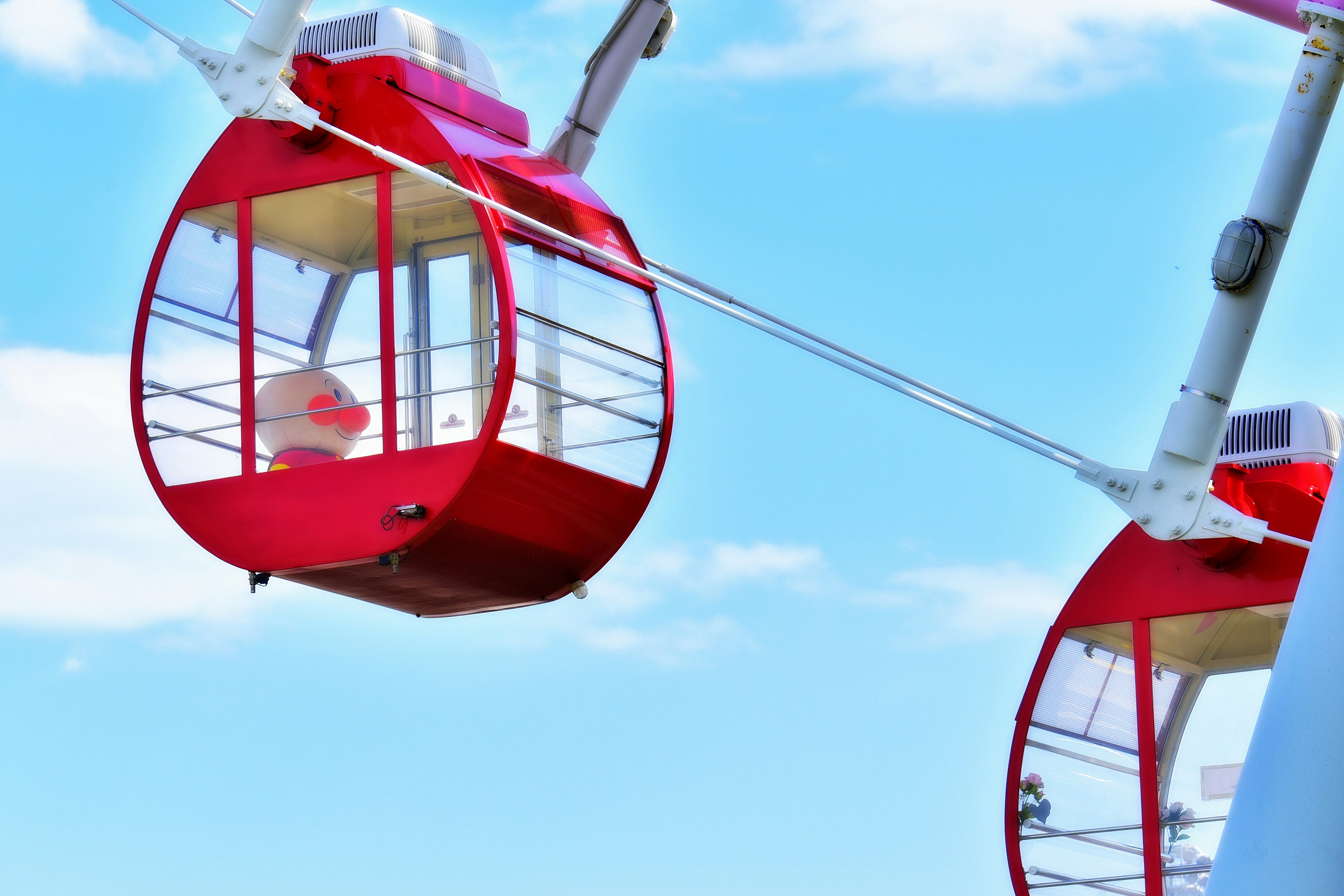 Red gondolas suspended against a blue sky