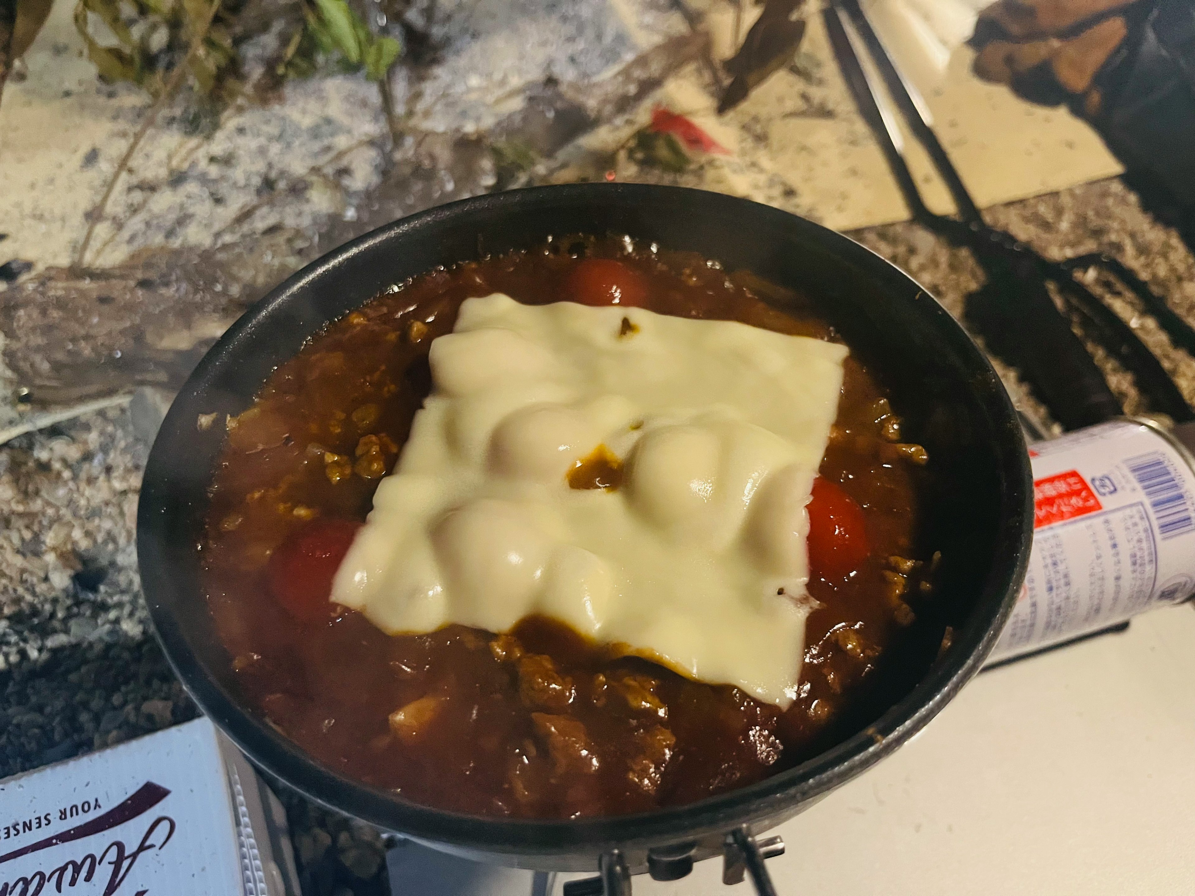 Una olla de estofado caliente cubierta con queso derretido