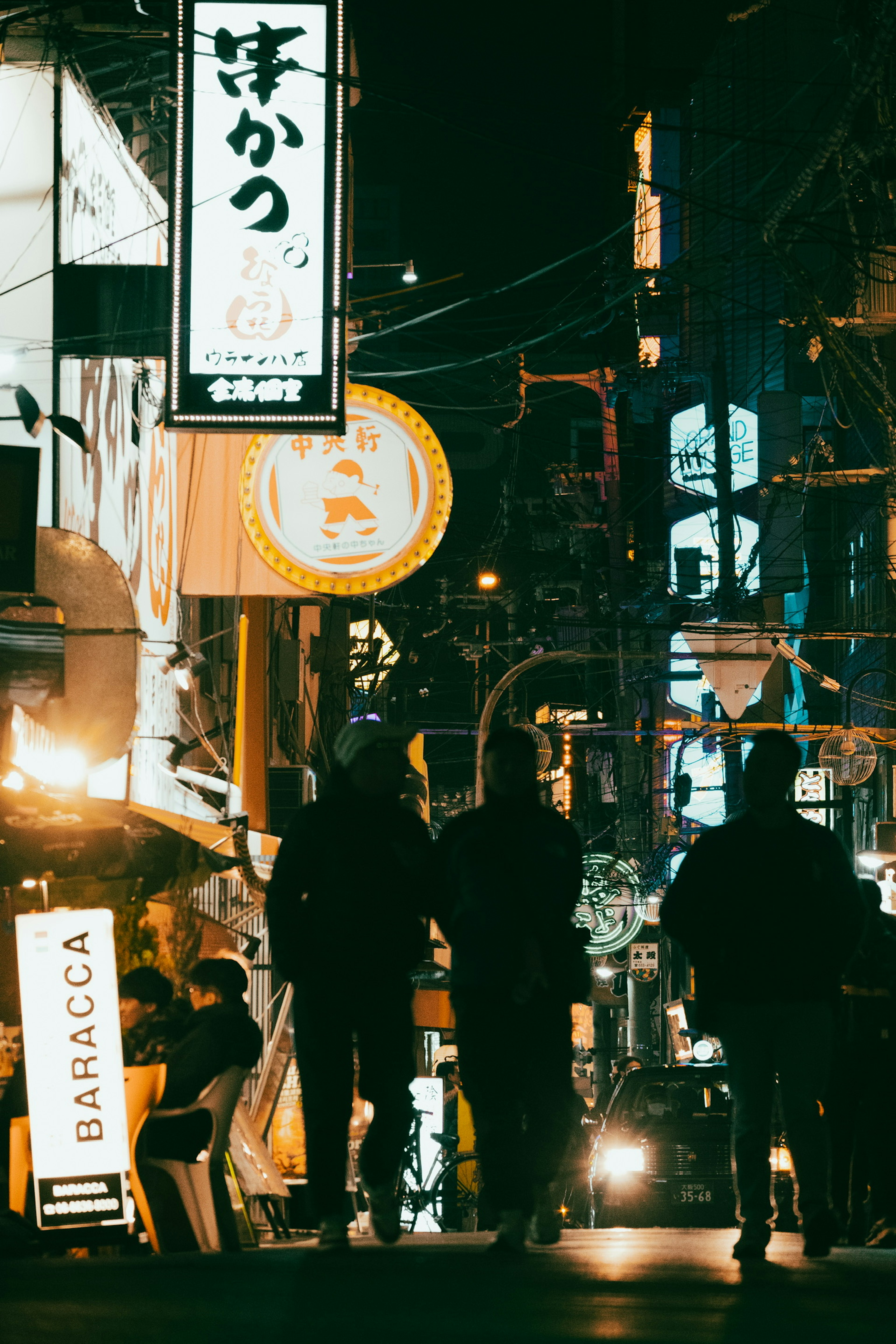 Orang-orang berjalan di jalan malam dengan tanda terang