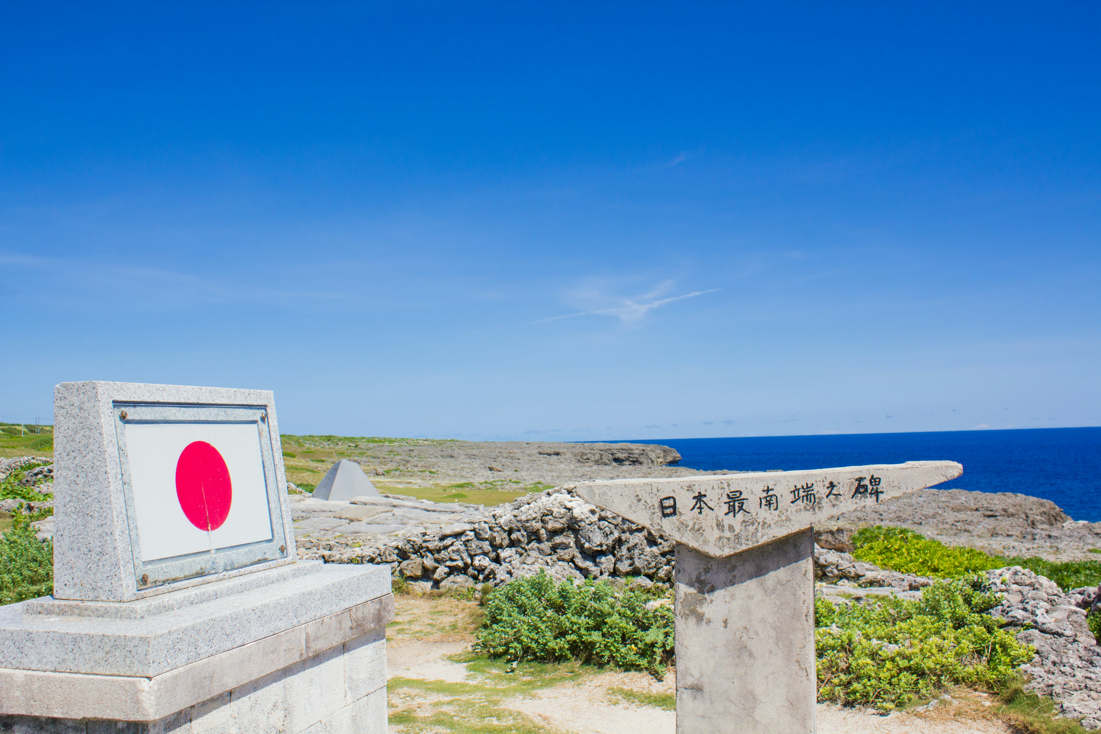 Tanda dengan bendera Jepang di latar belakang langit biru dan lautan