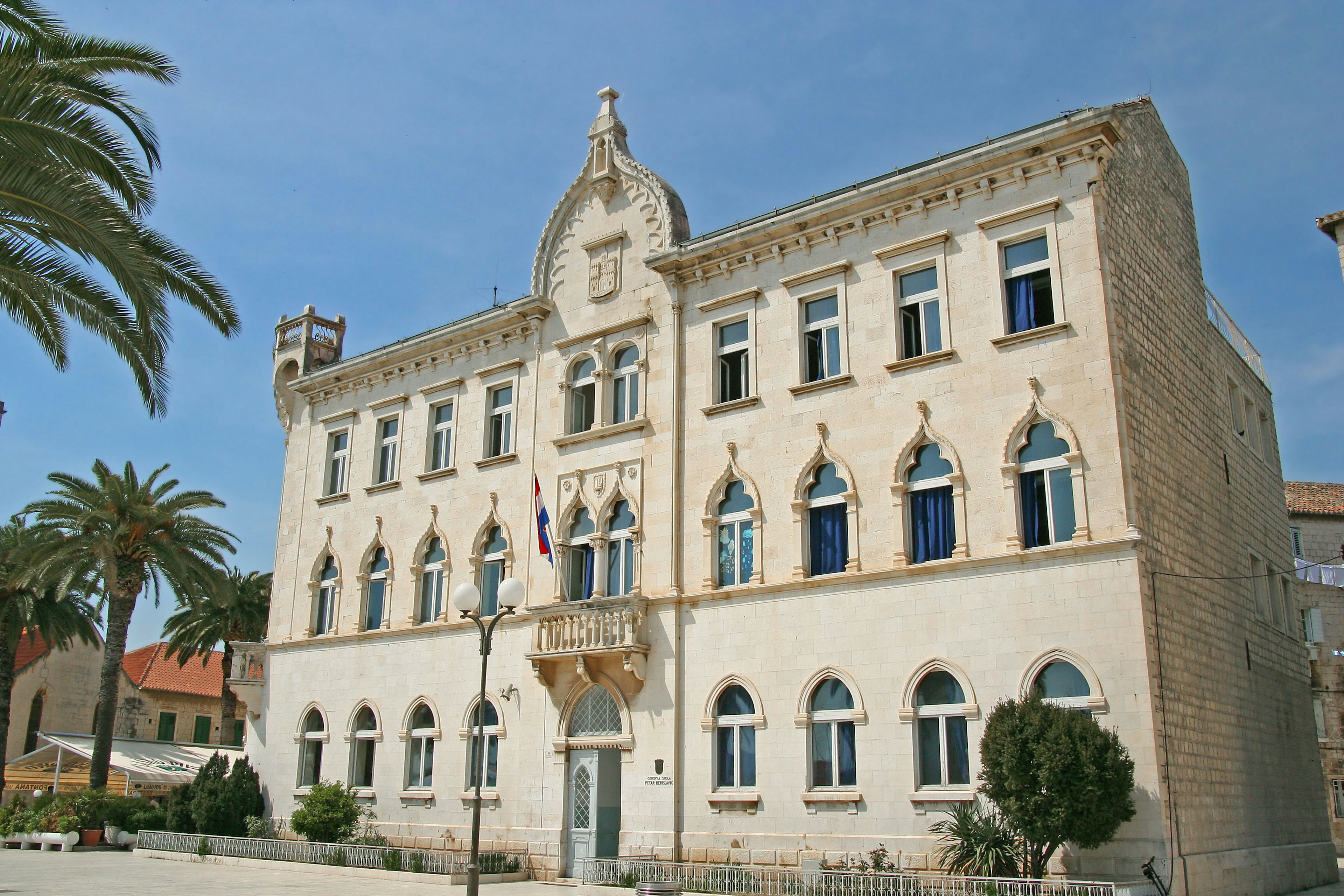 Historic building exterior featuring palm trees and blue sky