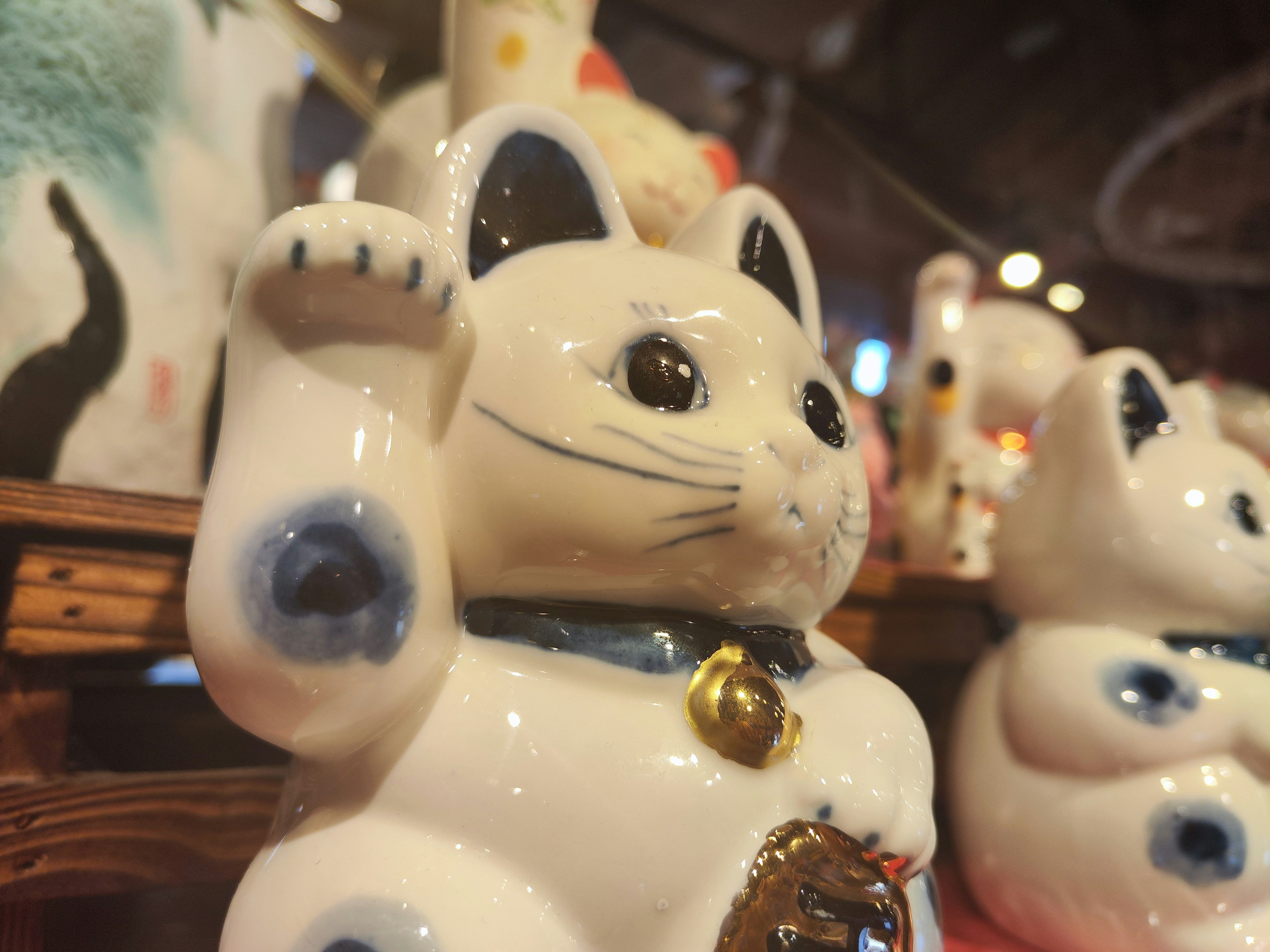 Figurina di gatto fortunato in ceramica bianca con una zampa alzata